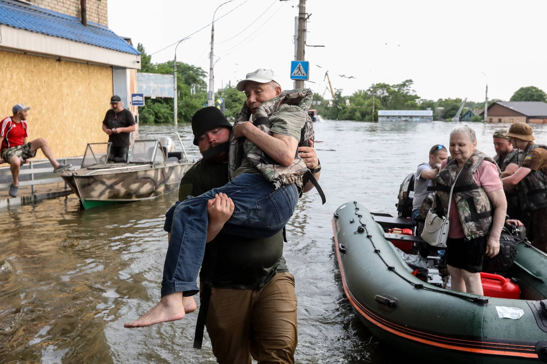 Residents are evacuated from a flooded area in Kherson
