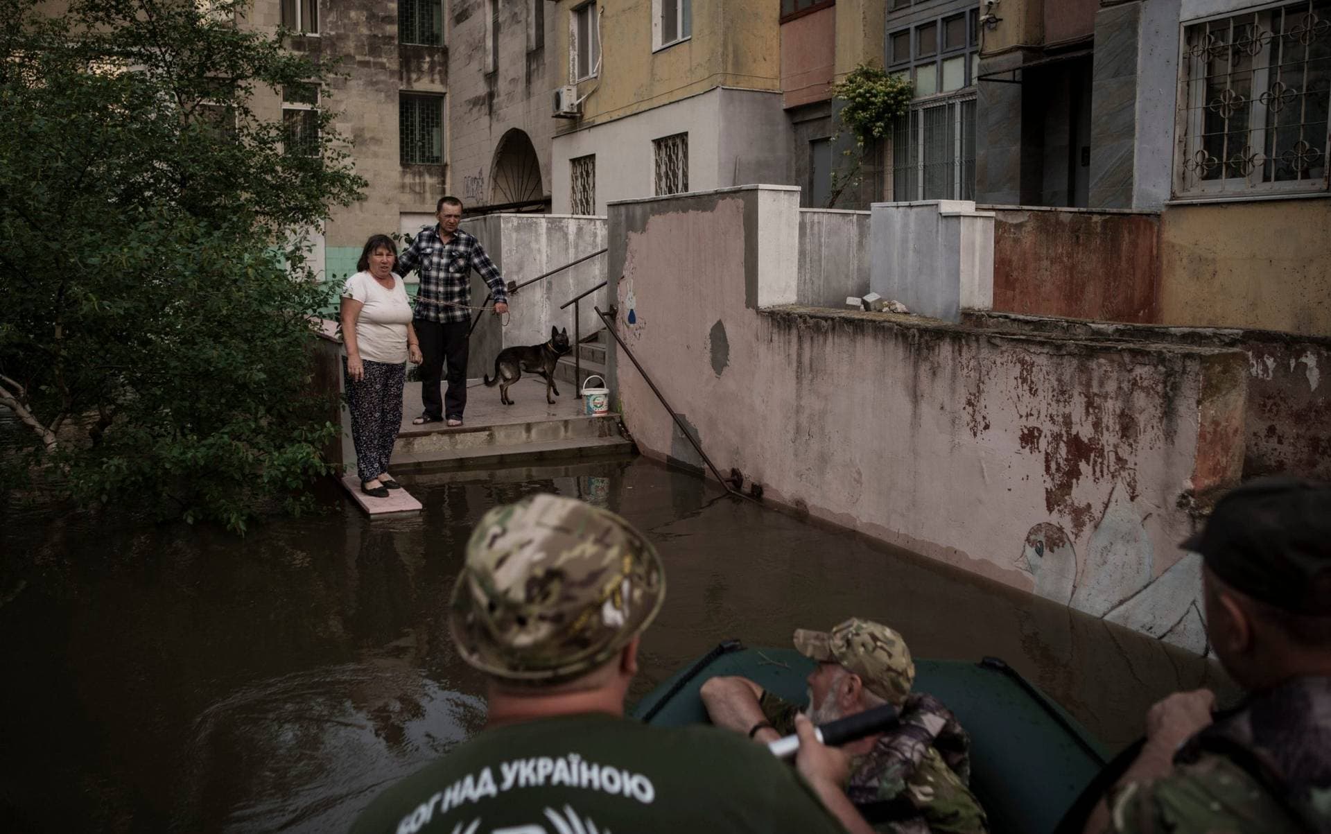 Military chaplains talk to residents stranded in a flooded neighbourhood in Kherson after the dam collapsed