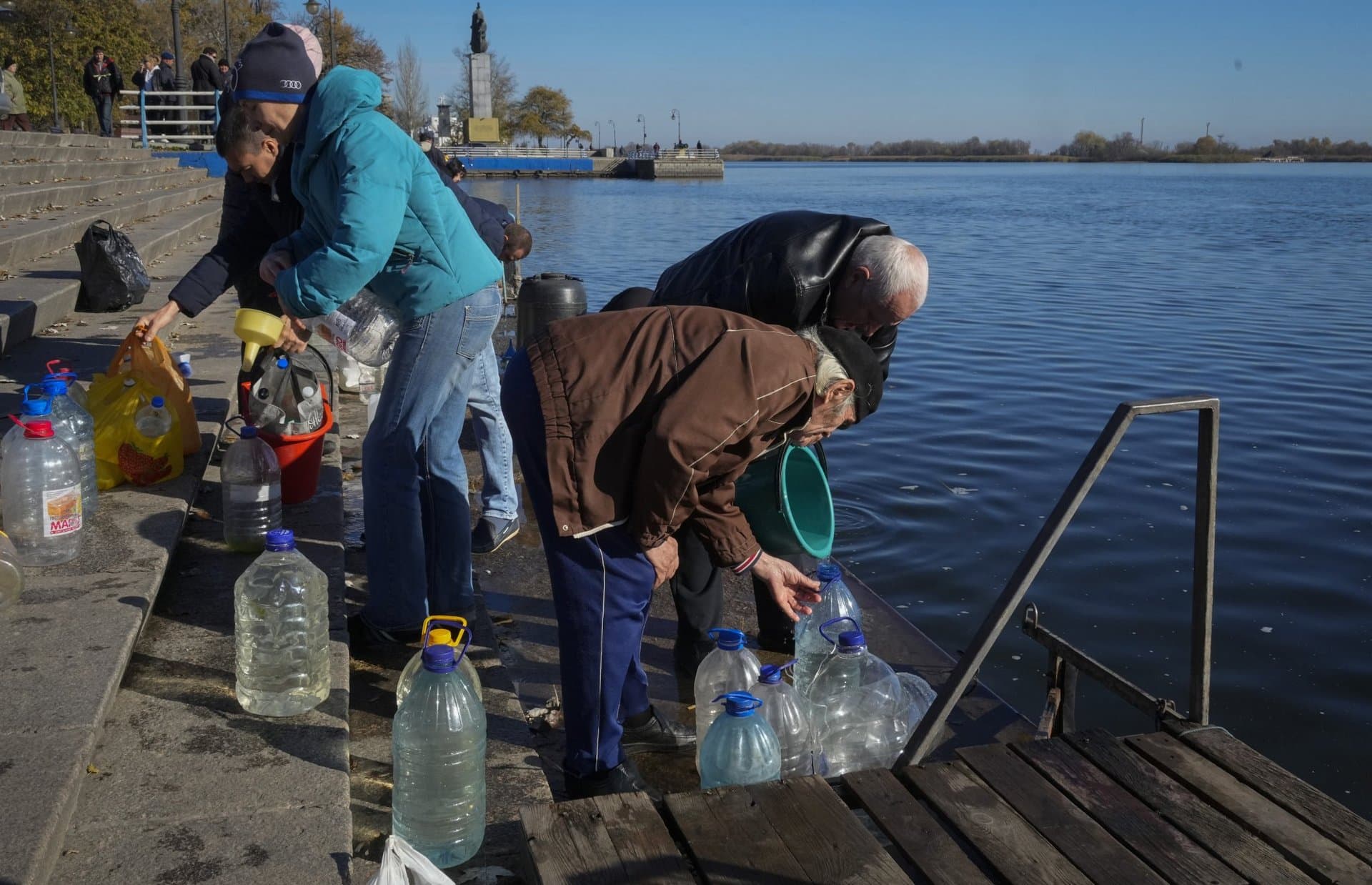 People collect water from a Dnipro river in Kherson