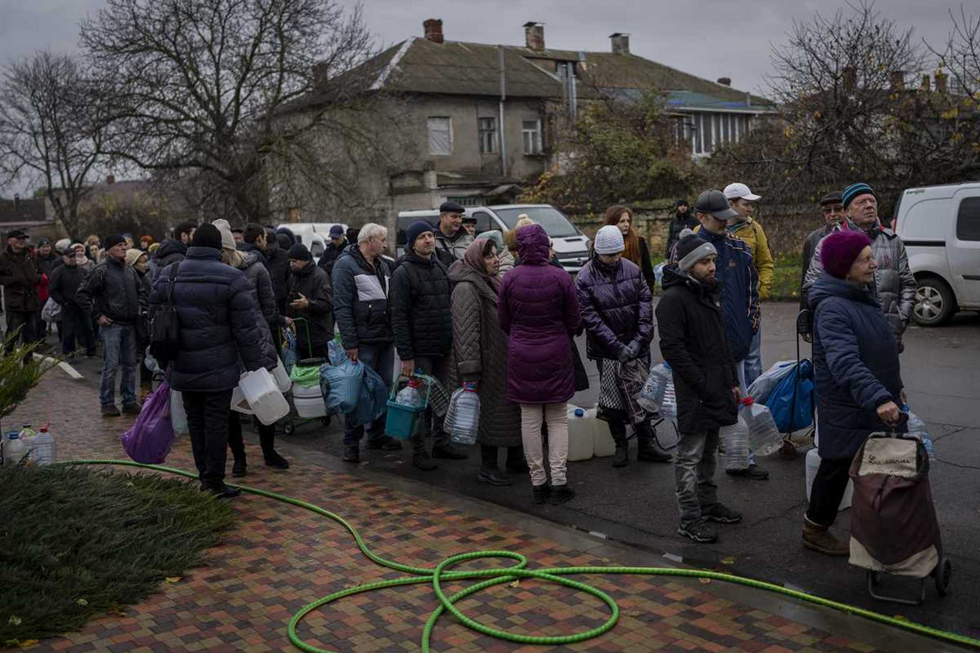Residents queue to fill containers with drinking water in Kherson