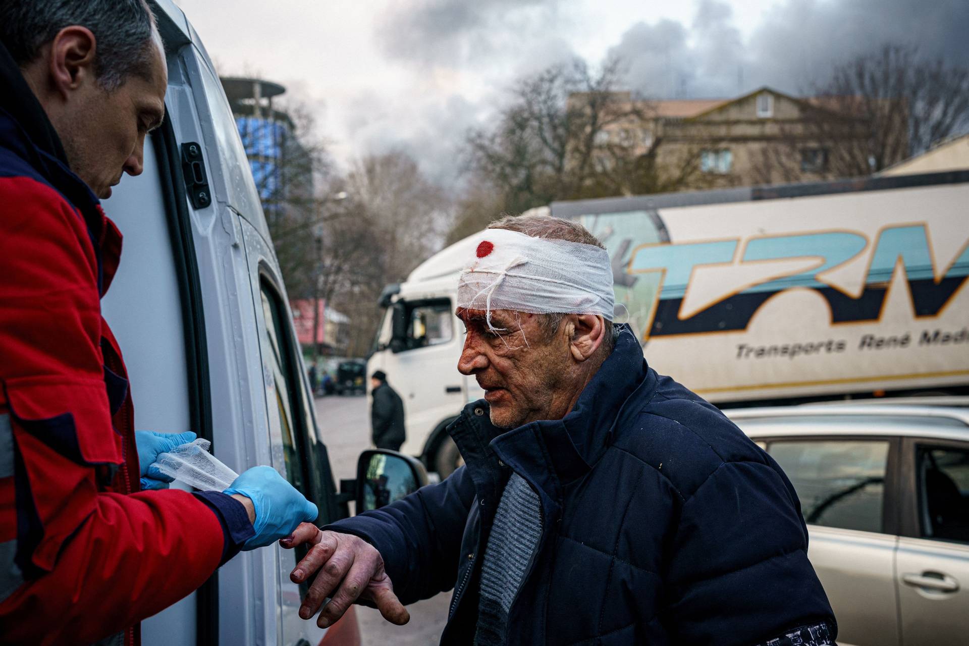 A rescue worker helps an injured man after Russian shelling on the Ukrainian city of Kherson on Saturday