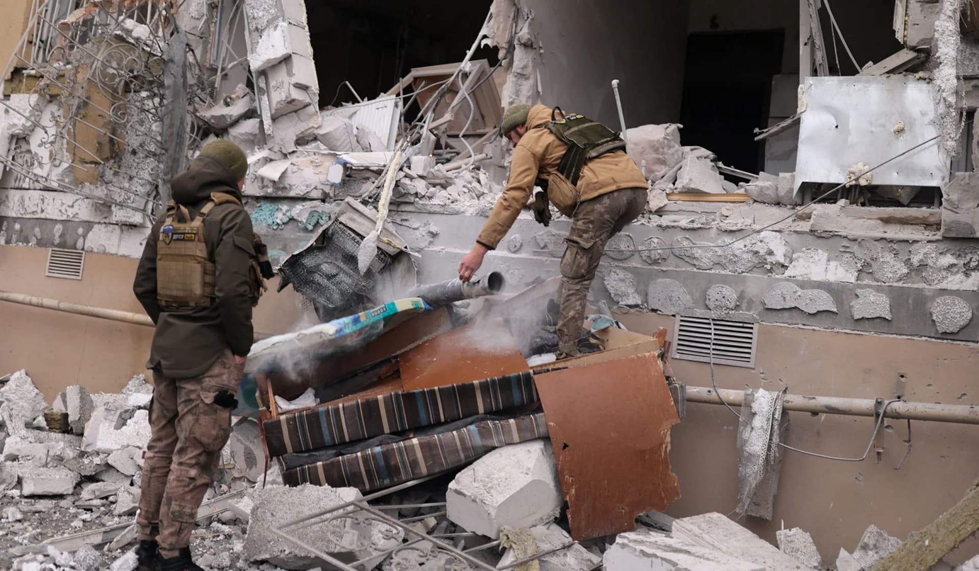 A local resident runs past a burning house hit by the Russian shelling in Kherson