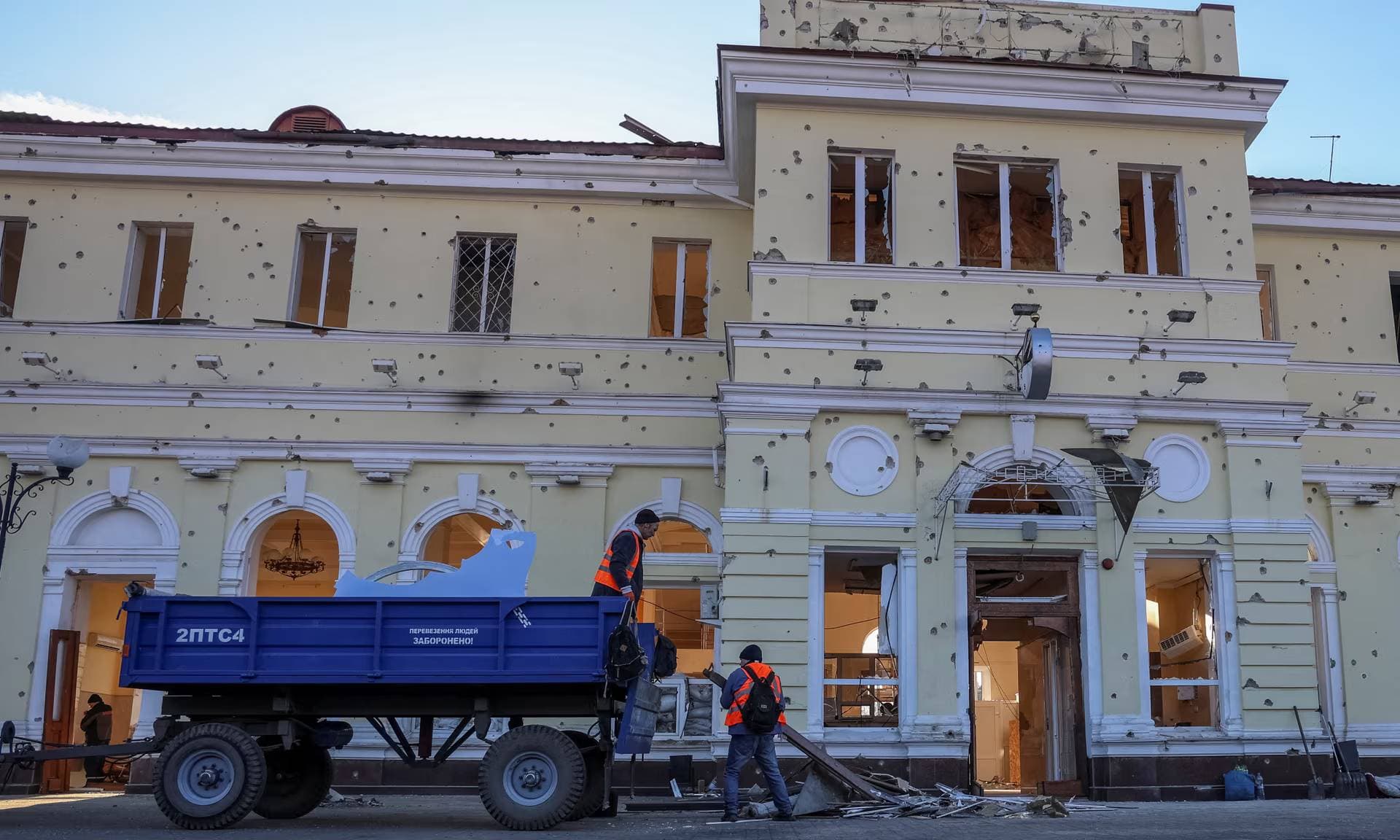 People at a gas station damaged by a Russian military strike in Kherson