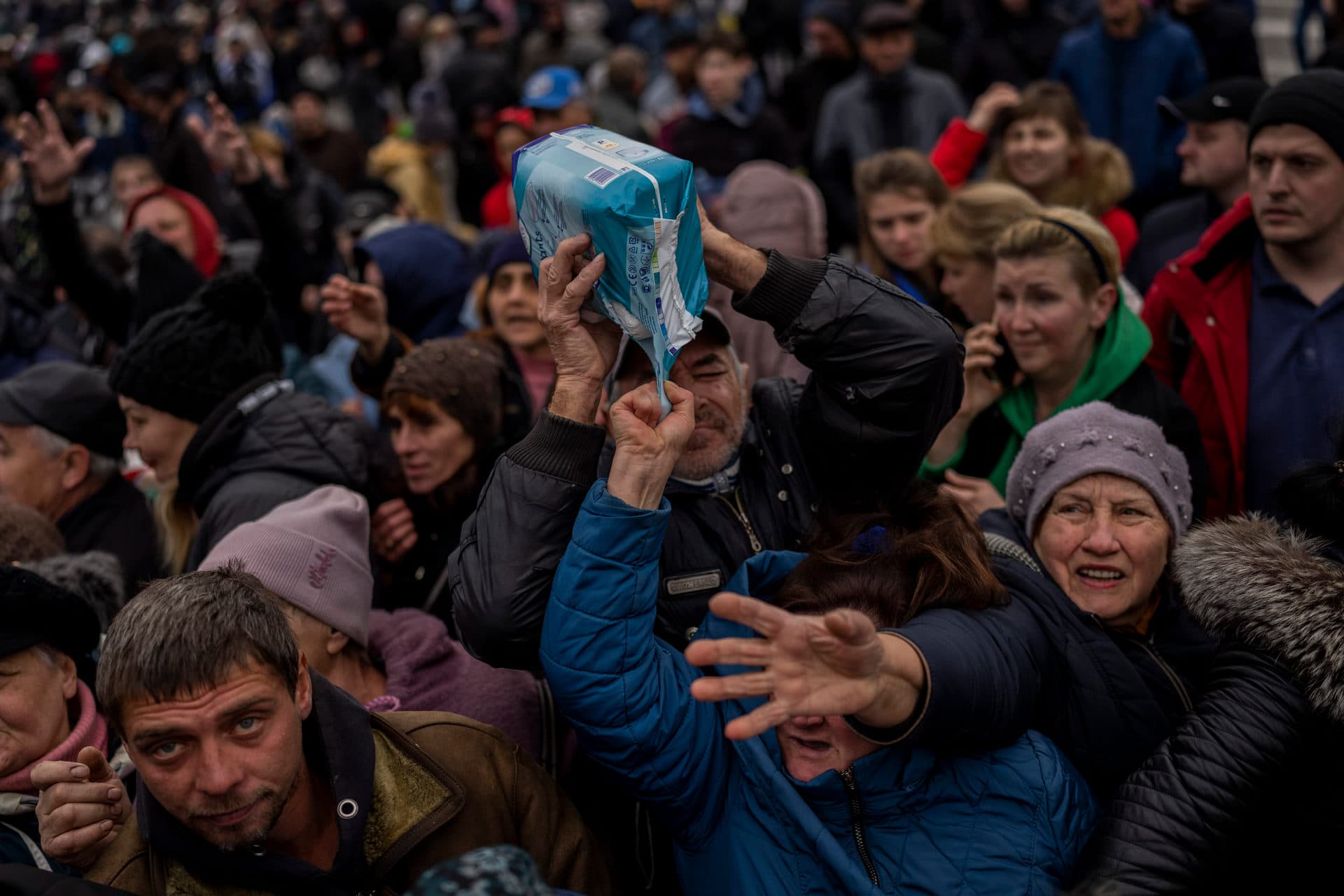 Residents gathering at an aid distribution point receive supplies in downtown Kherson