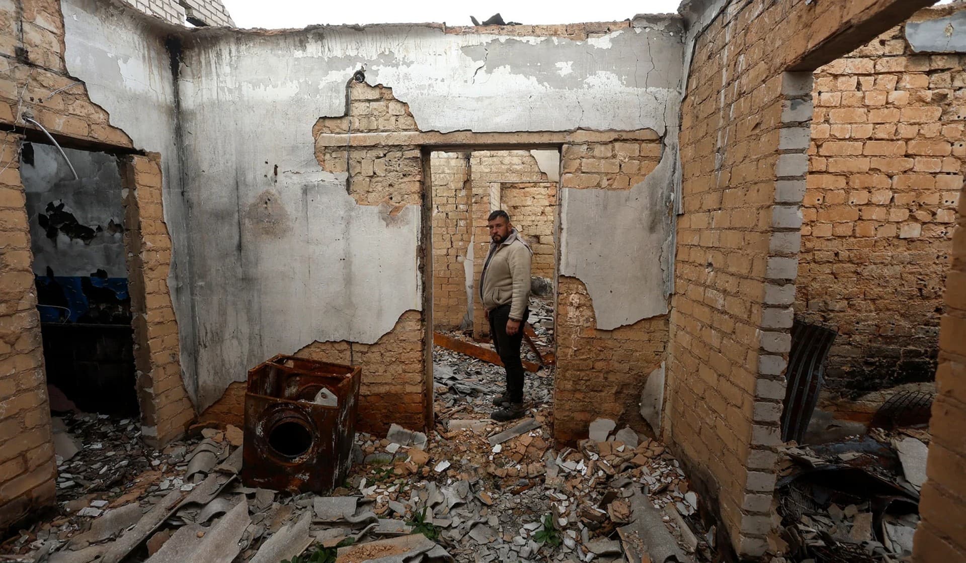 Serhii Kalko shows a house burned by Russian soldiers during an occupation in the village of Blahodatne, retaken by the Ukrainian Armed Forces a day ago, in Kherson Region