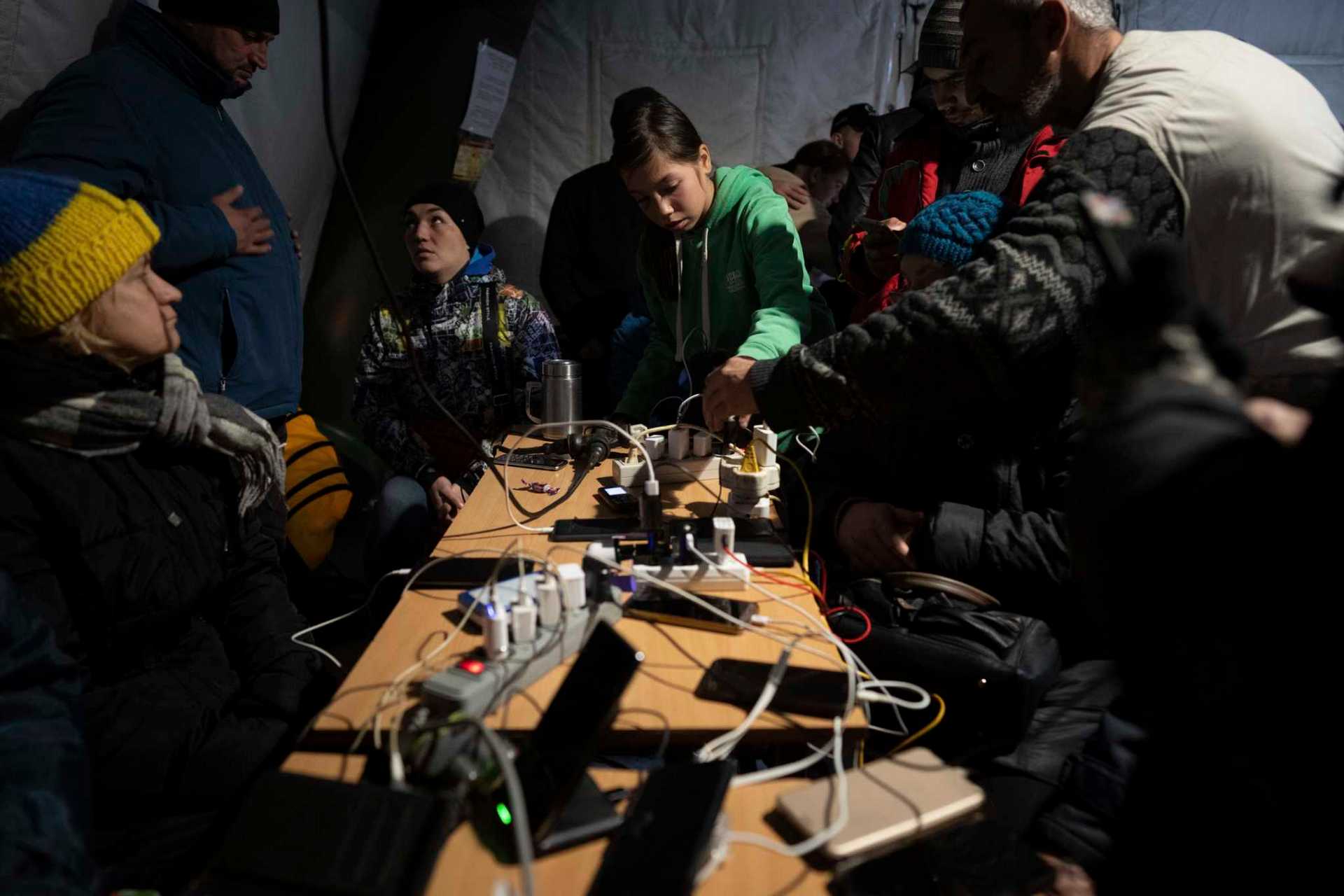 People charge their phones at a 'Point of Invincibility' in Kherson