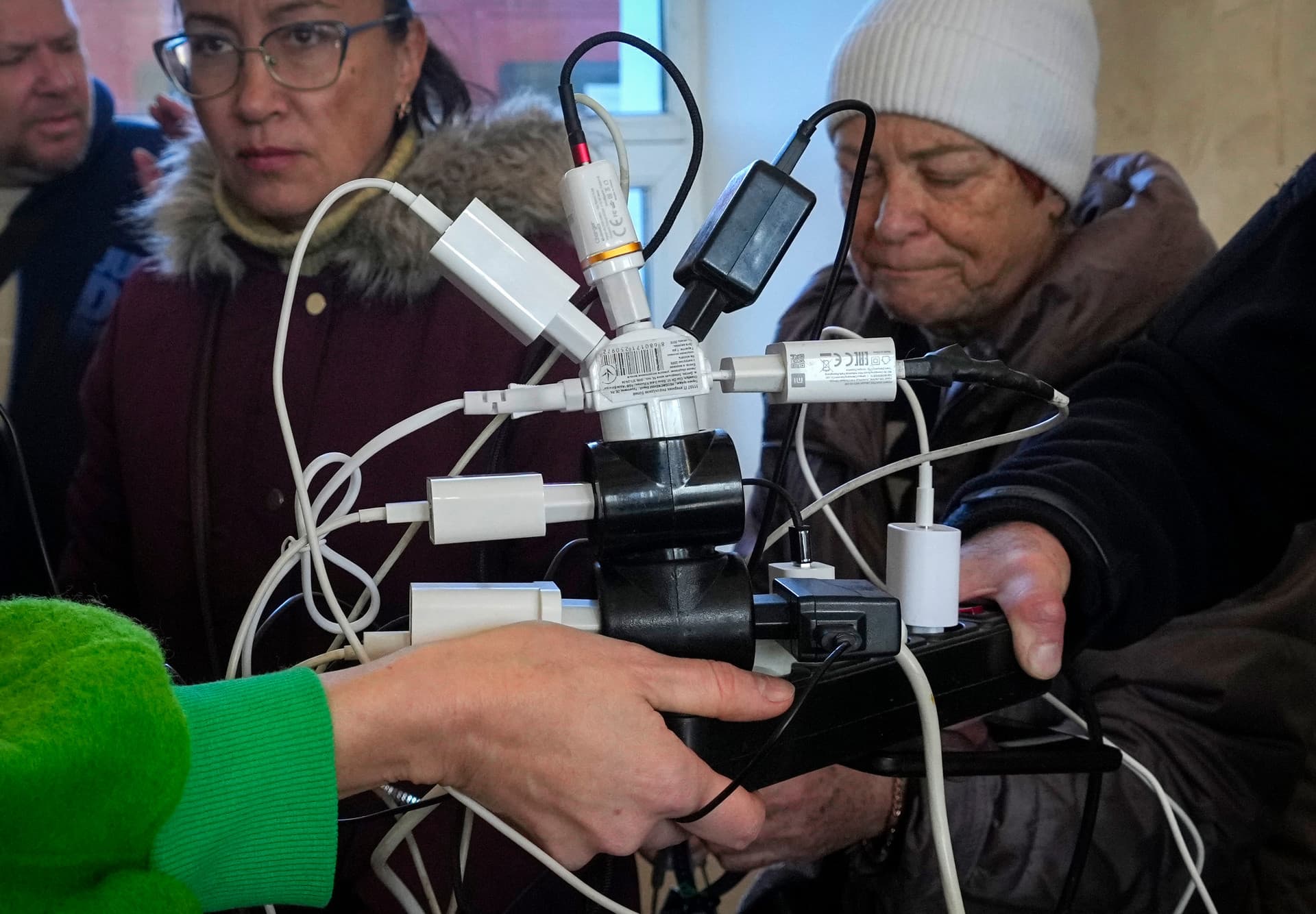 People charge their phones, try to connect to the internet and make phone calls, in central square in Kherson