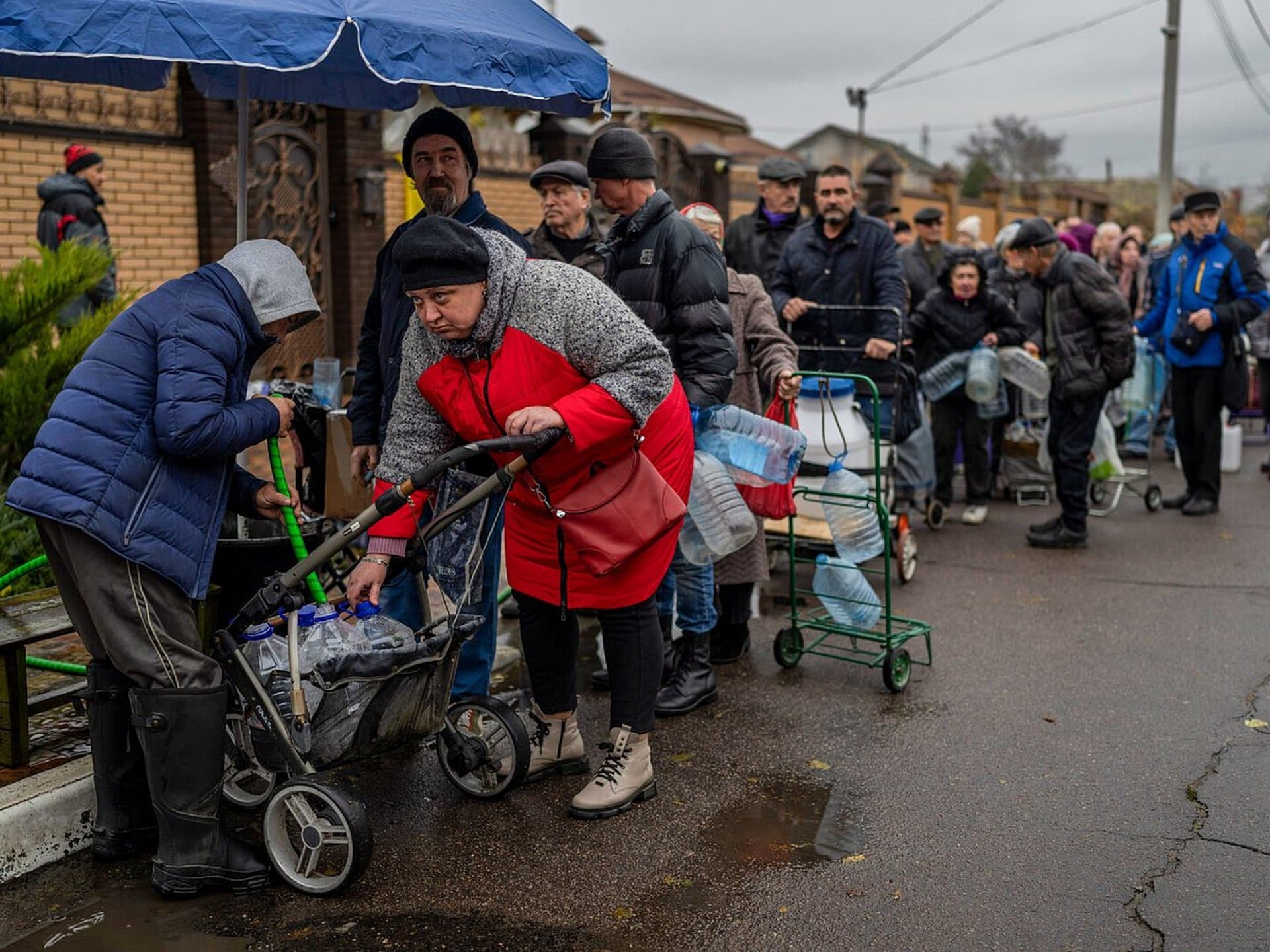 Residents queue to fill containers with drinking water in Kherson
