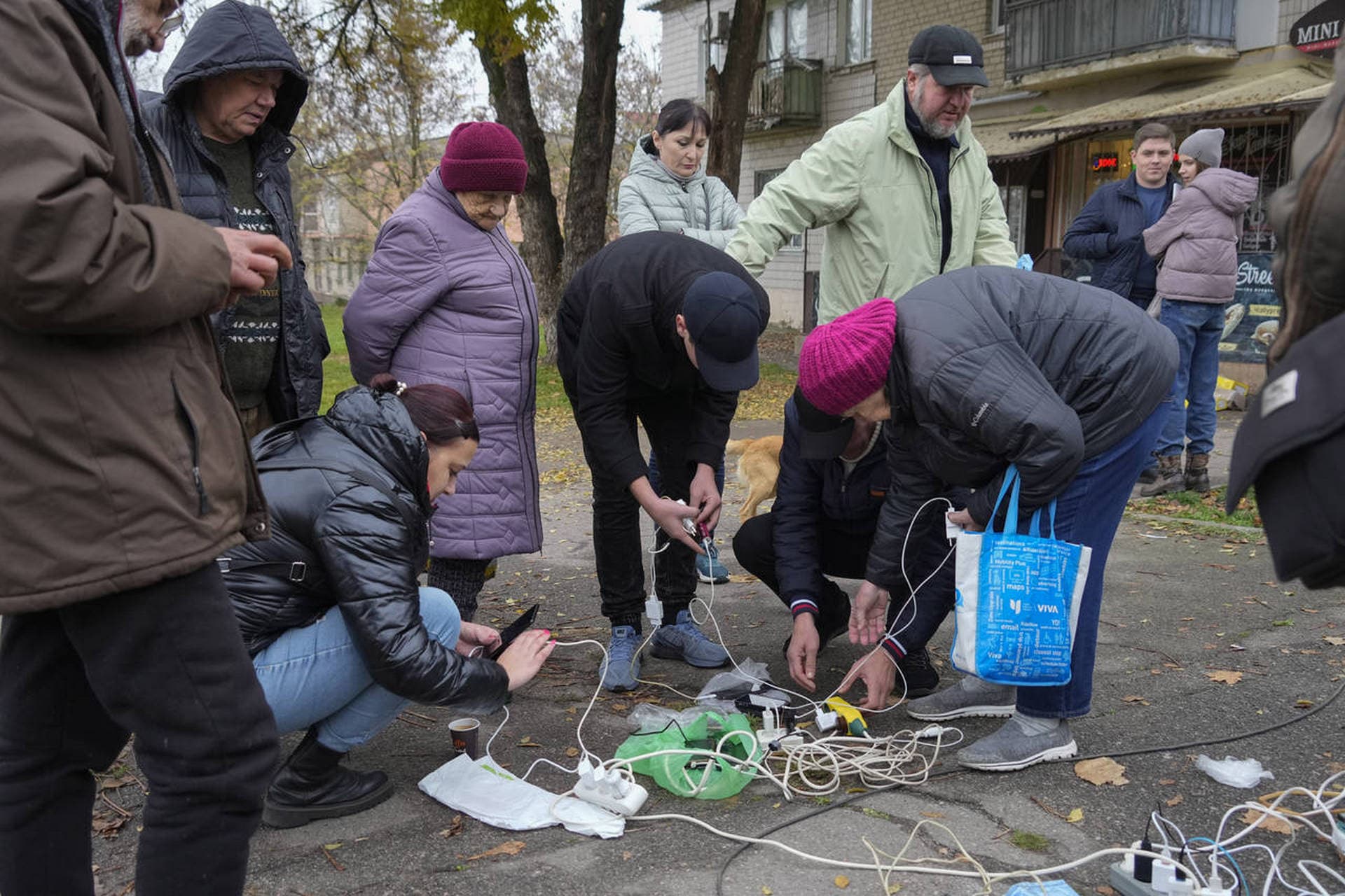 People charge their phones, try to connect to the internet and make phone calls on central square in Kherson