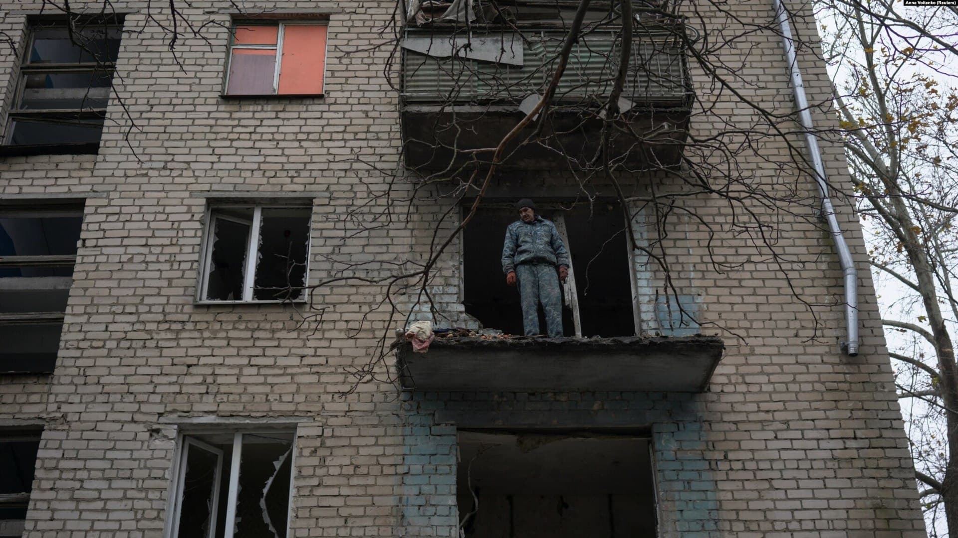 Oleksandr Antonenko looks down on destruction from damaged apartment of residential building in Kherson