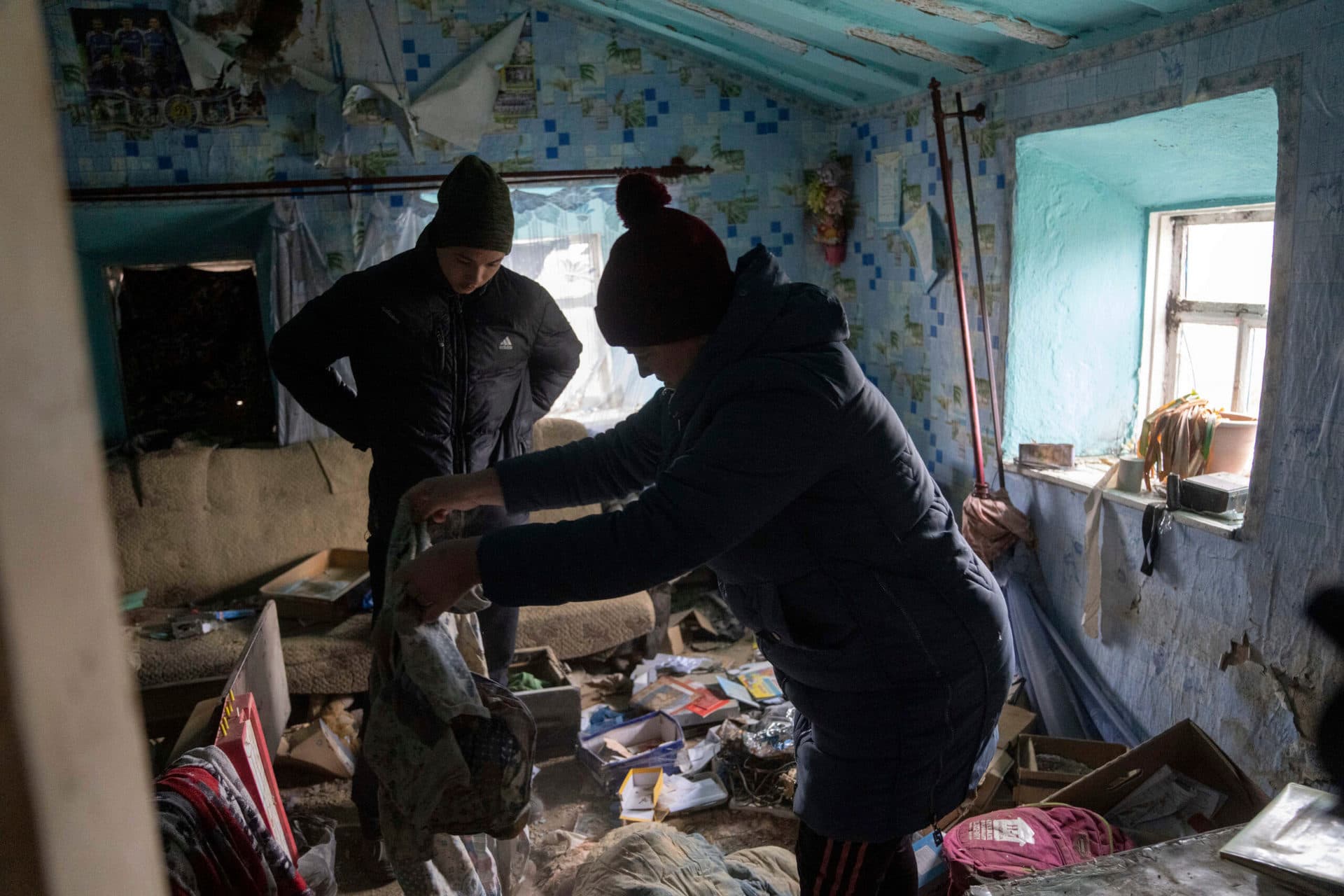 A family look through their possessions at their house in recently liberated village of Pravdyne