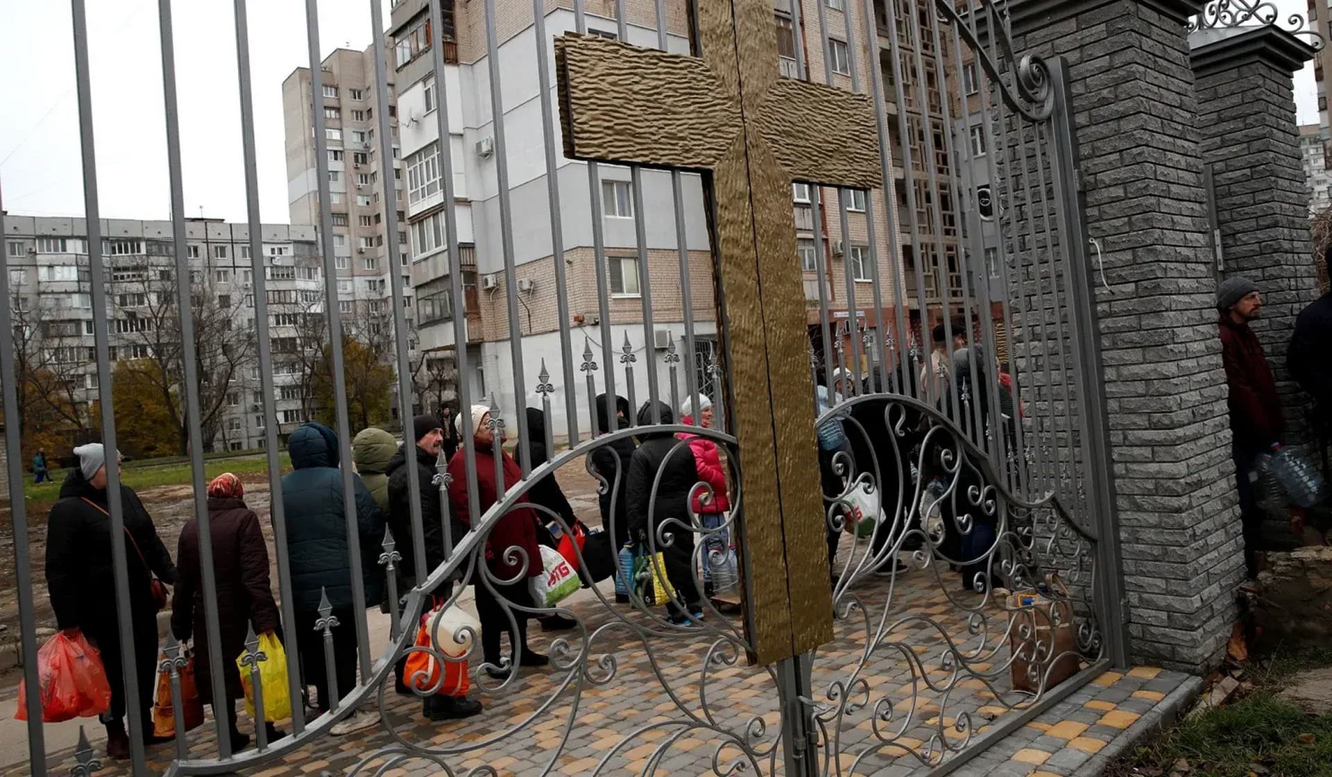 People wait in line to get food, water, and aid in Kherson