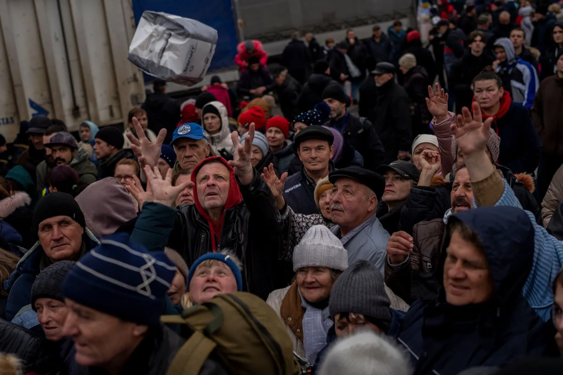 Residents gathering at an aid distribution point receive supplies in downtown Kherson