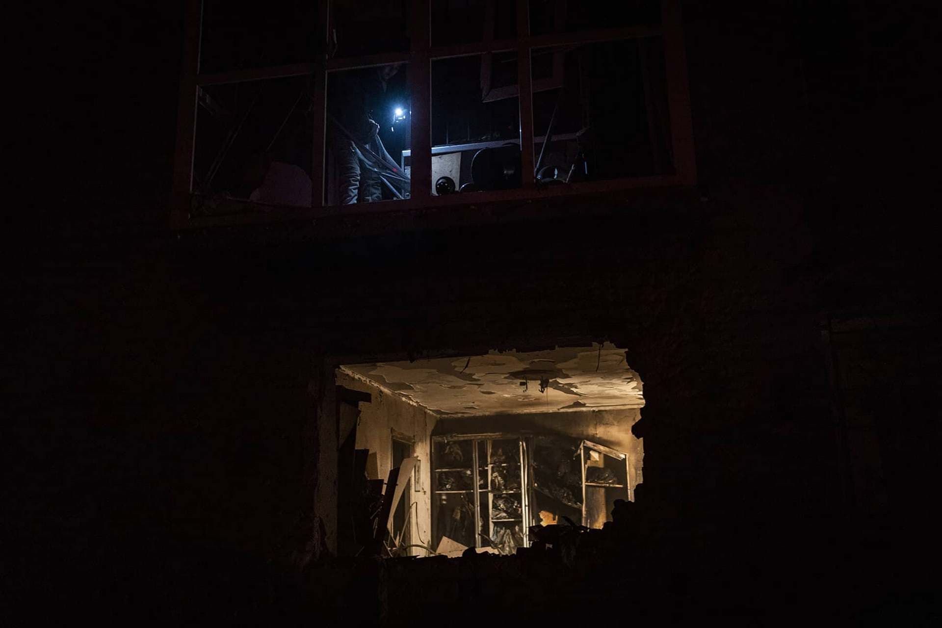 A resident look at the damage in a building after a Russian strike in Kherson