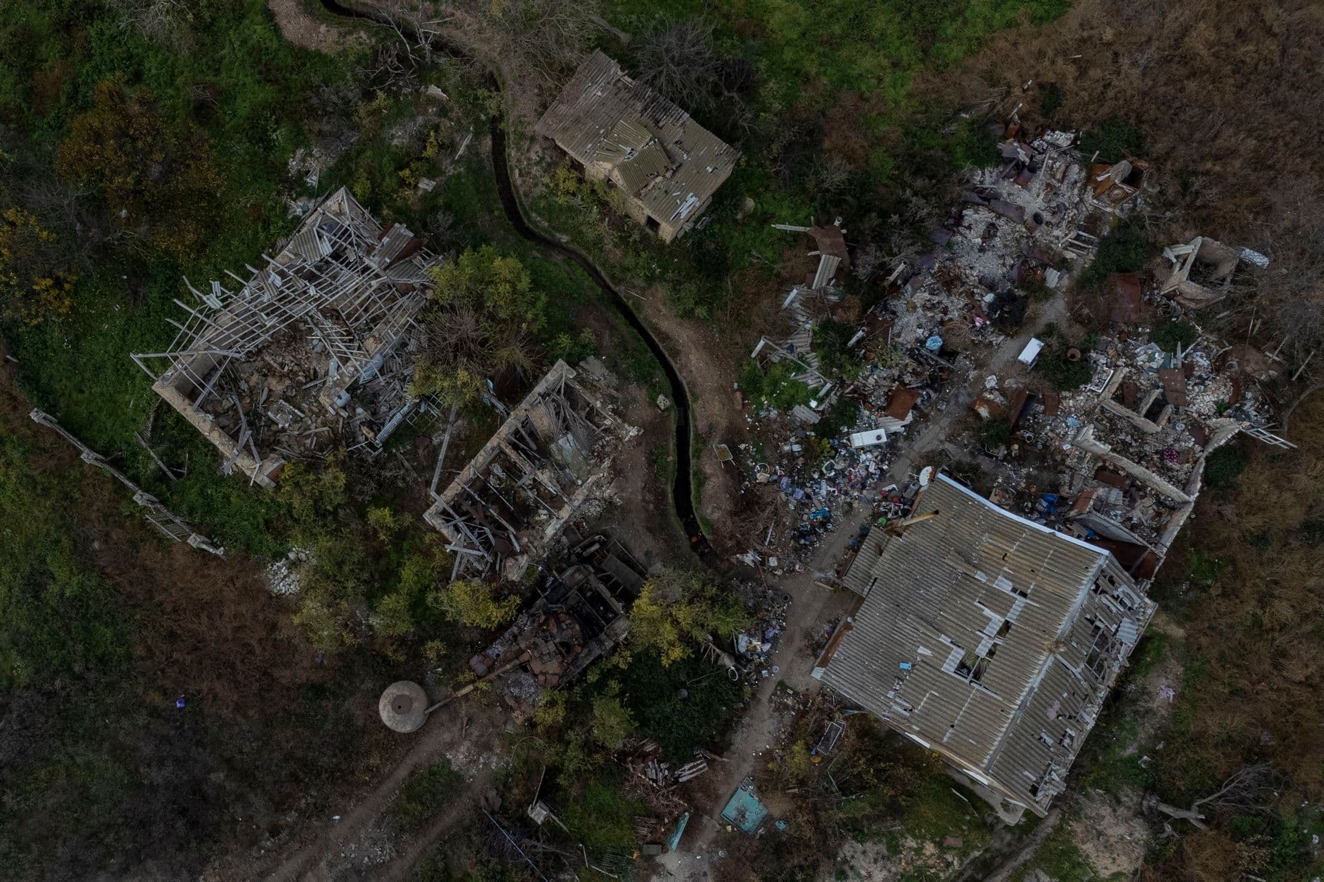 A view of a Russian tank and destroyed buildings of a recently liberated village on the outskirts of Kherson