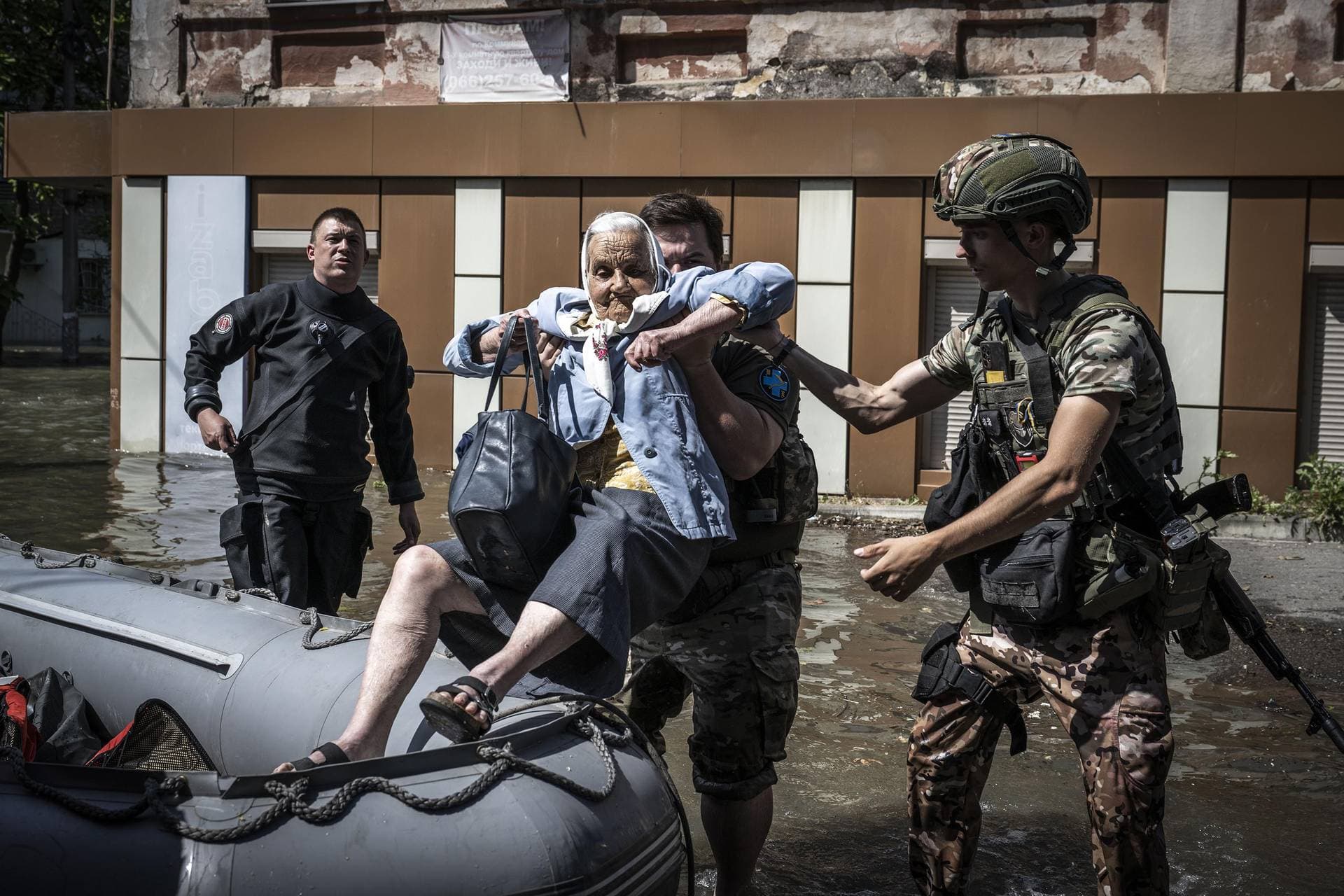 An elderly woman is evacuated from a flooded area in Kherson