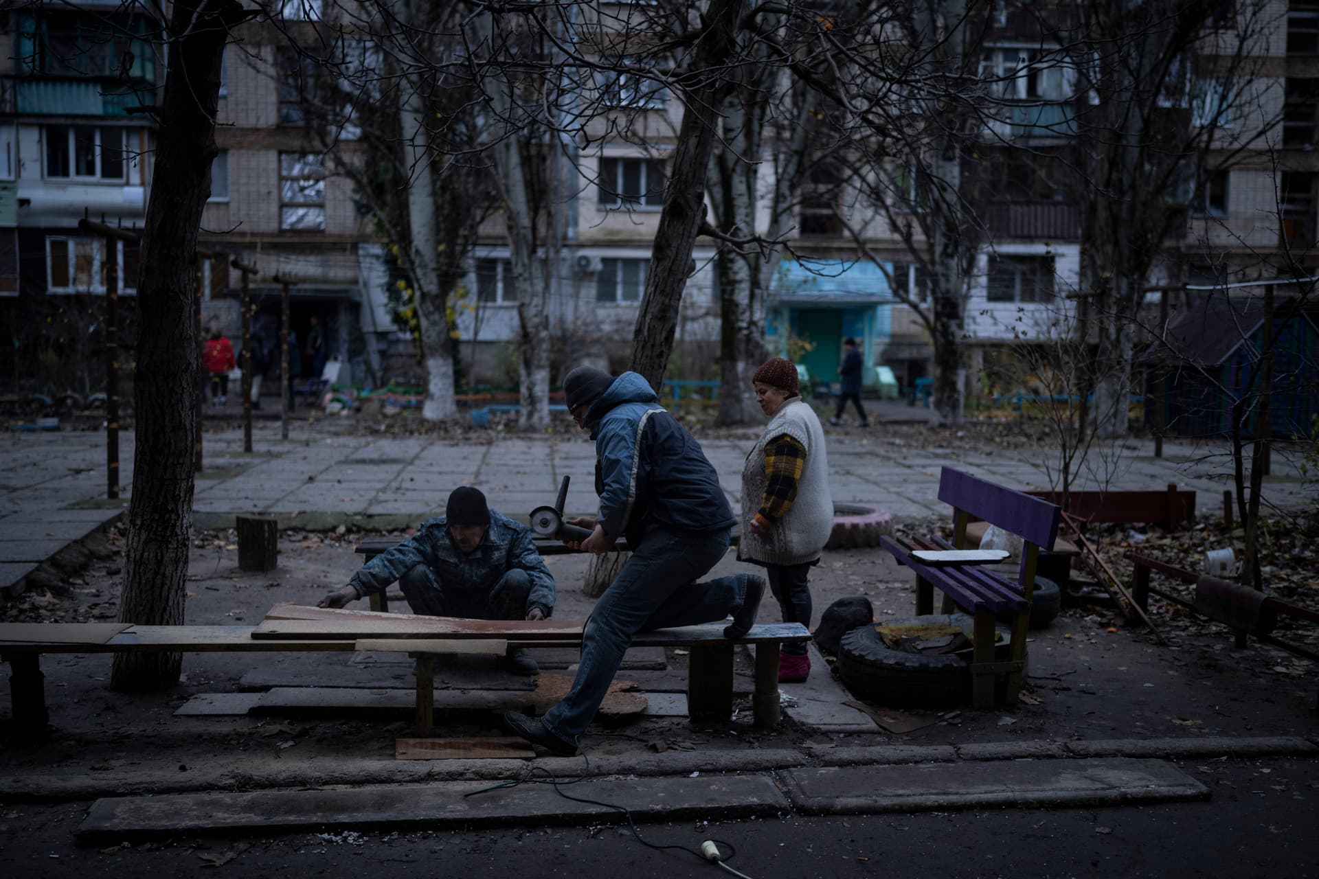 Residents do repair works on a recently damaged building during a Russian strike in the southern city of Kherson