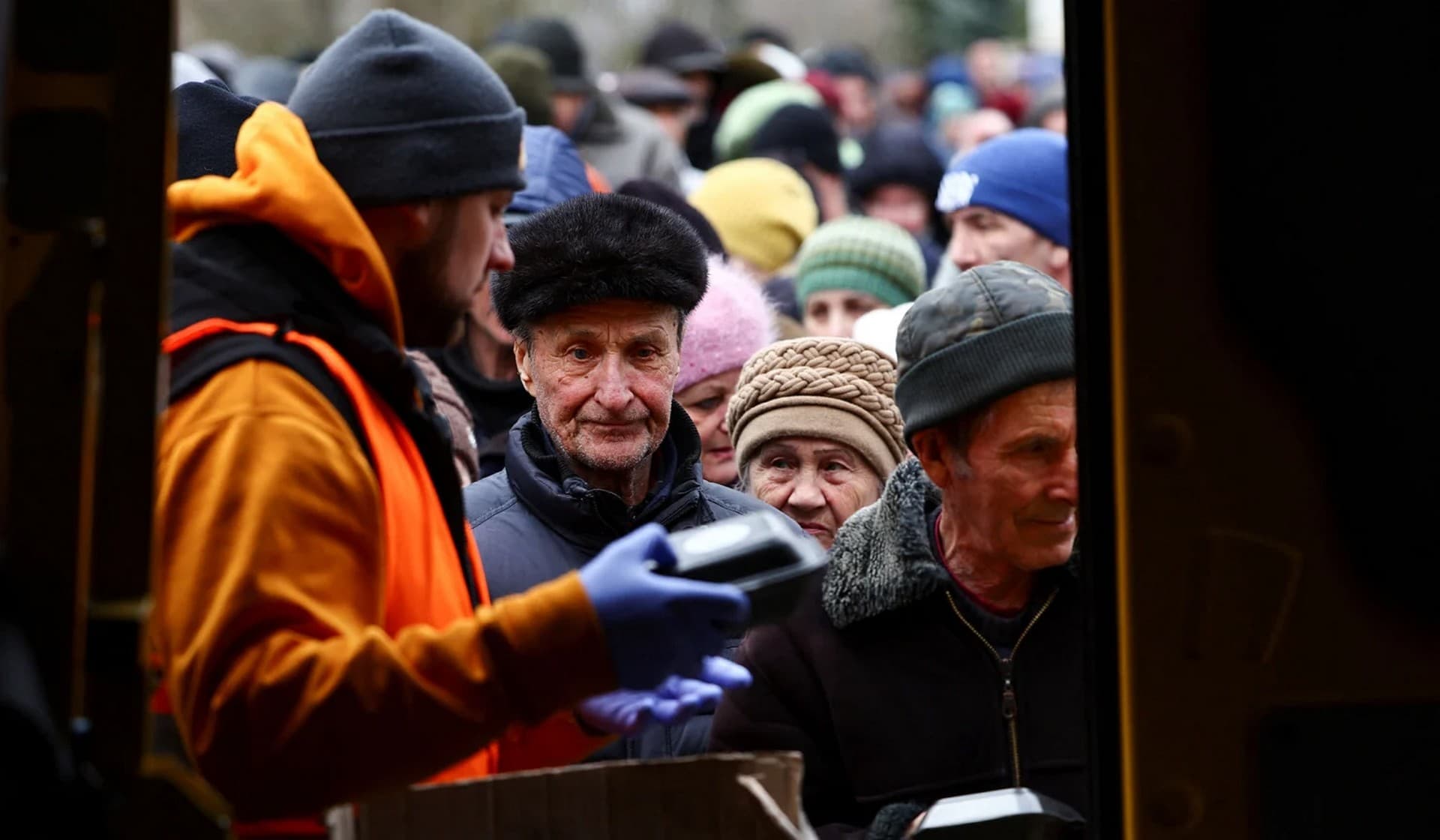 People receive meals from World Central Kitchen food truck on a street in Kherson