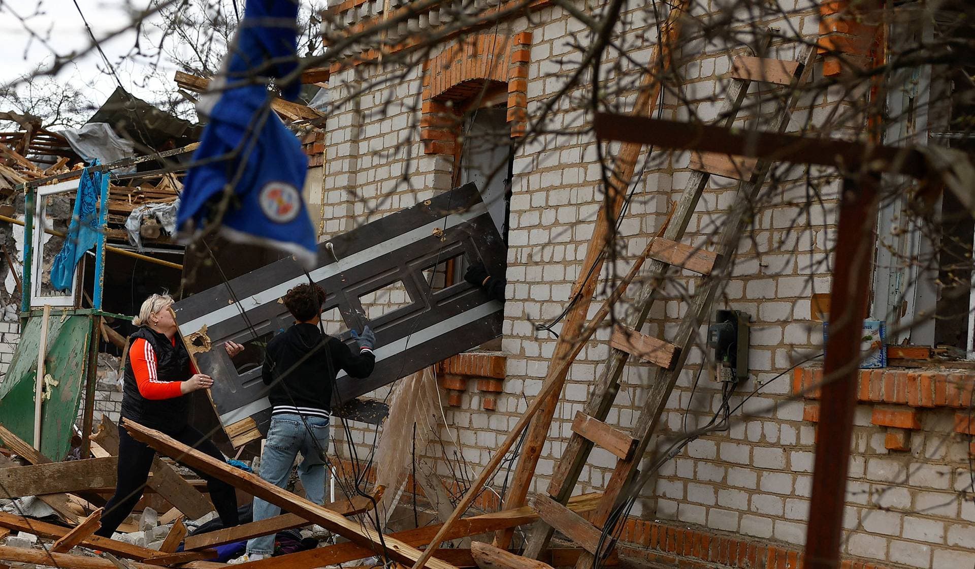 Residents remove debris at the site of a house heavily damaged during a Russian missile strike in Korosten