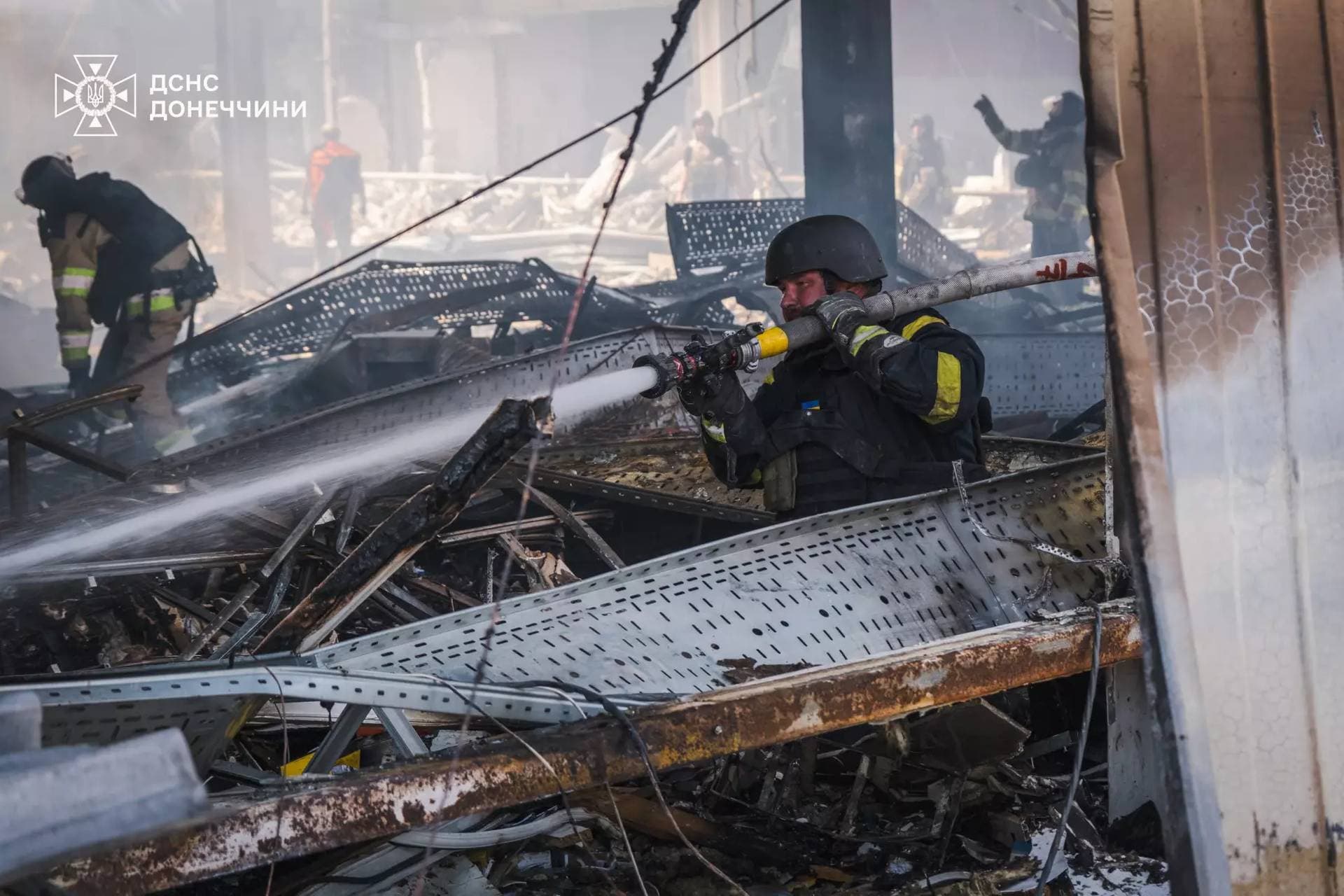 Firefighters work inside a supermarket heavily damaged by a Russian military strike in Kostiantynivka