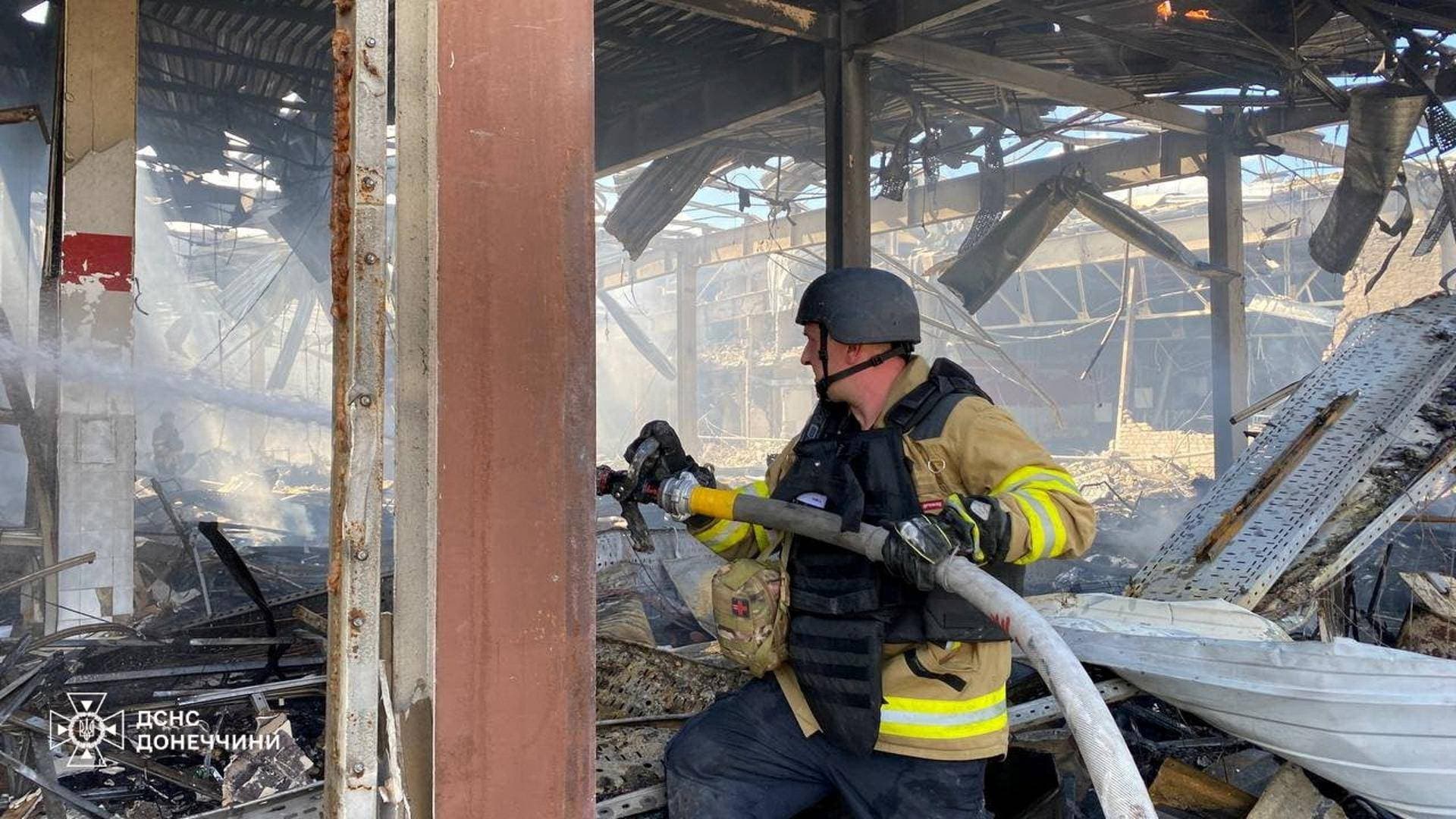 Firefighters work inside a supermarket heavily damaged by a Russian military strike in Kostiantynivka
