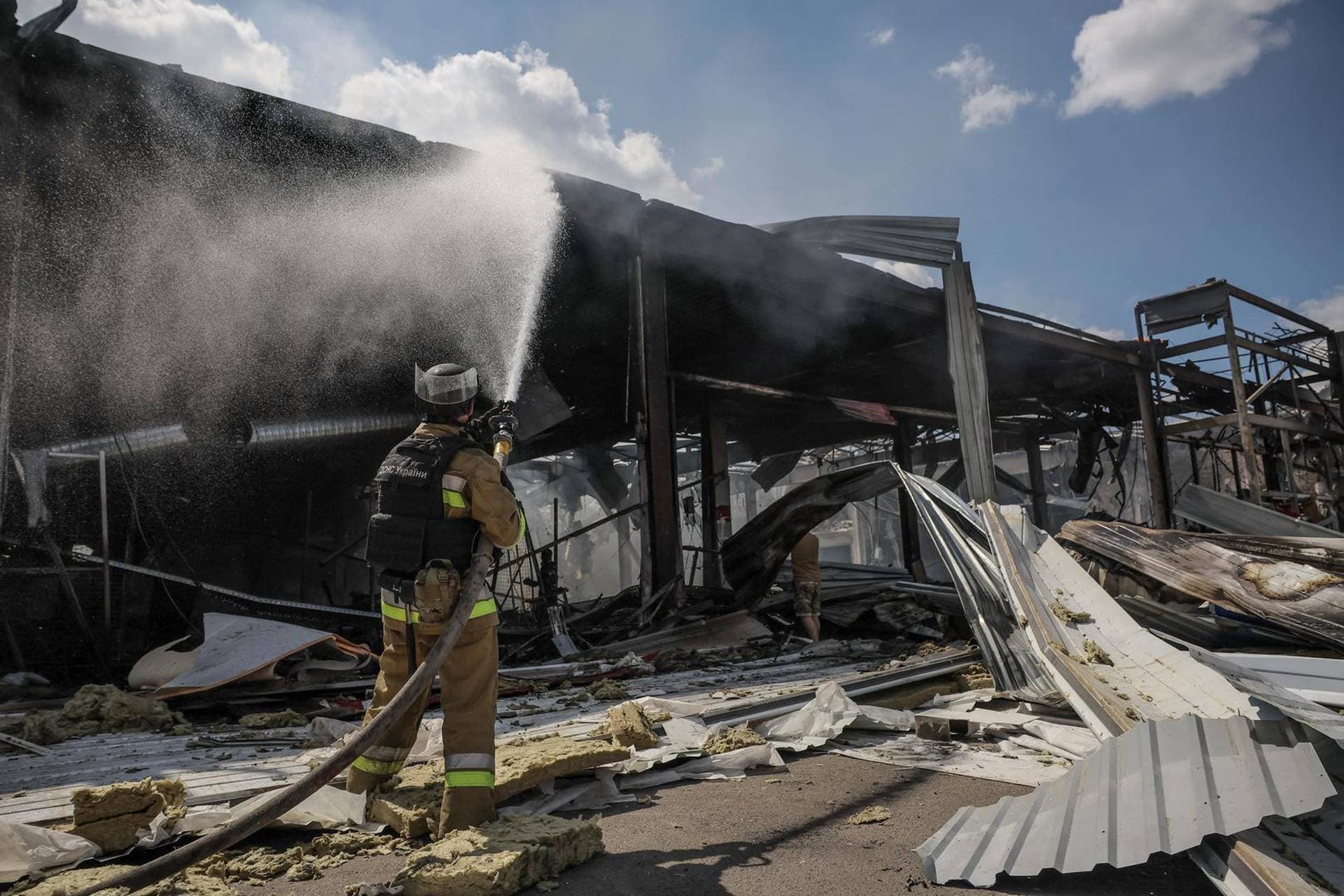 Firefighters work at a site of a supermarket heavily damaged by a Russian military strike in Kostiantynivka