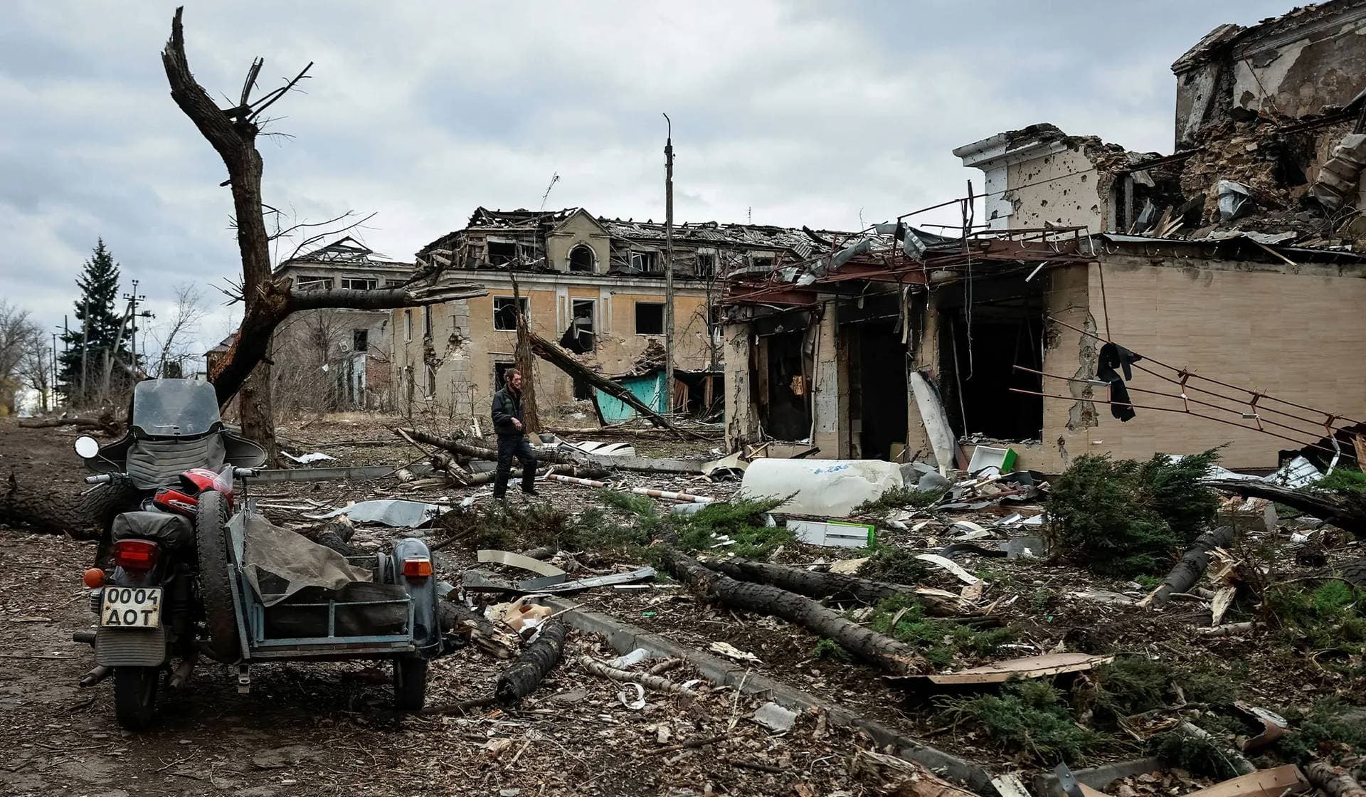 A resident walks near apartment buildings damaged by a Russian military strike in the frontline town of Kostiantynivka