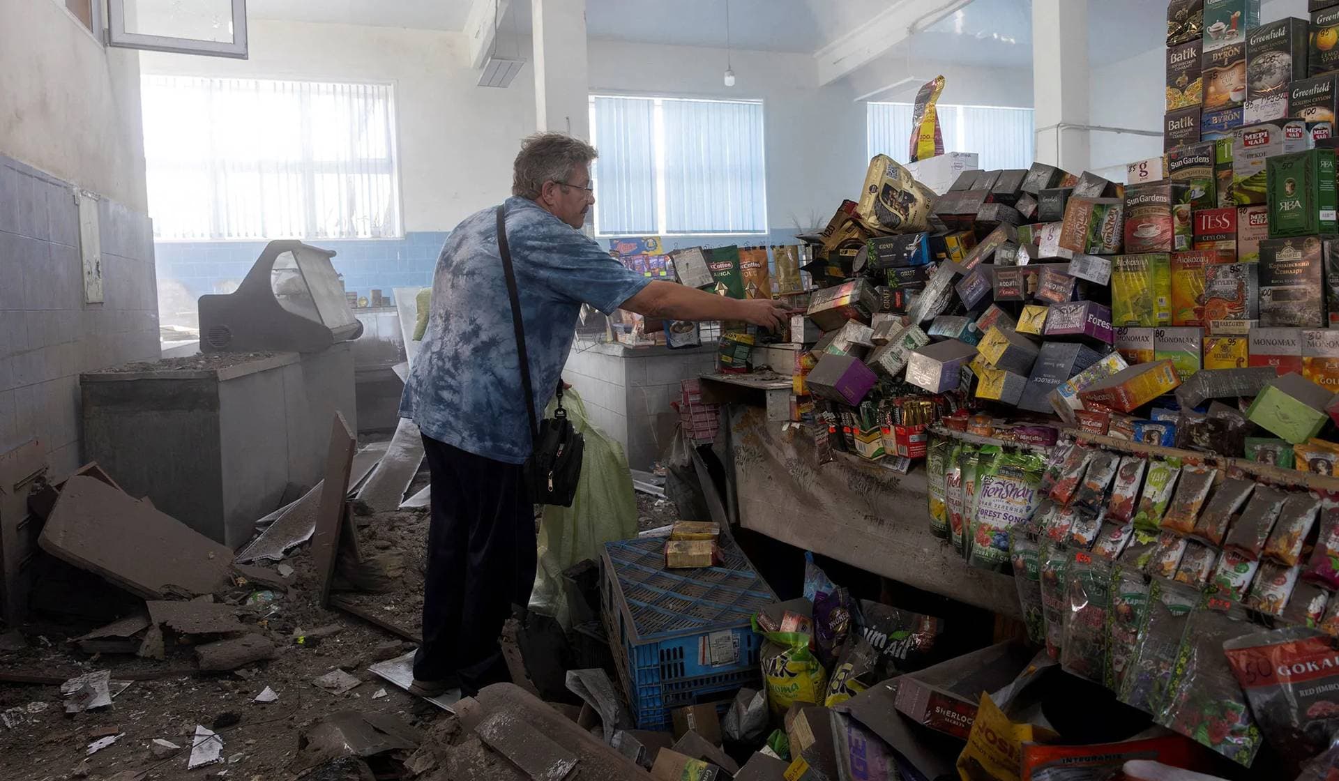 A market trader cleans up his stall after a Russian drone struck the roof and exploded in Kramatorsk