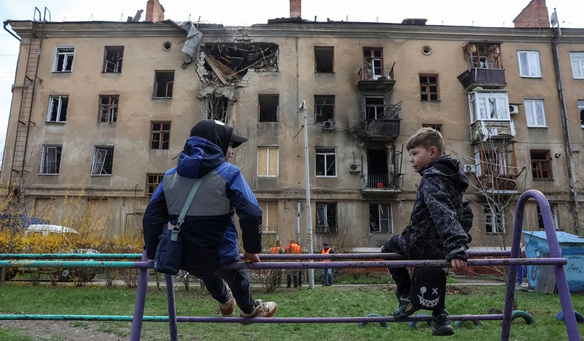 Children play near an apartment building hit by a Russian drone strike in Kramatorsk