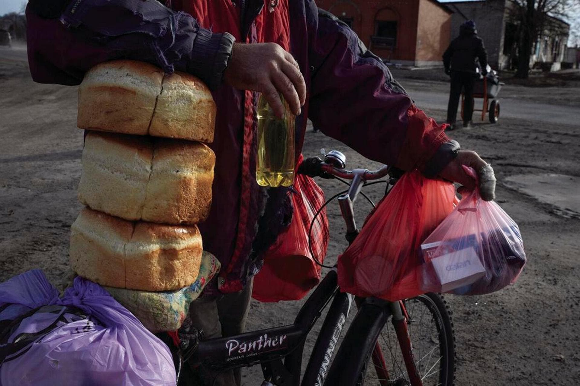 Local resident receives a food at a mobile humanitarian aid point in the village of Zarichne