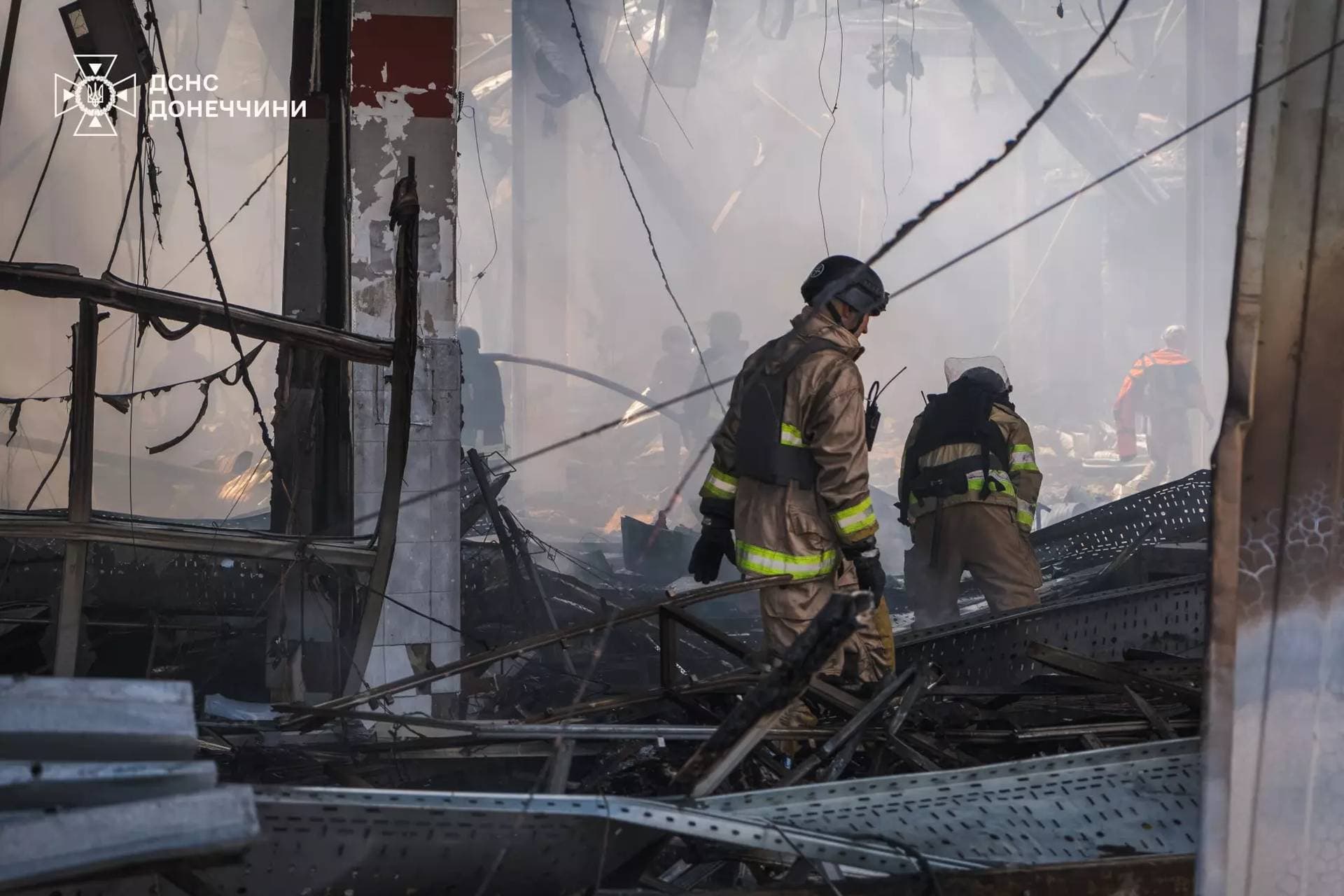 Firefighters work inside a supermarket heavily damaged by a Russian military strike in Kostiantynivka