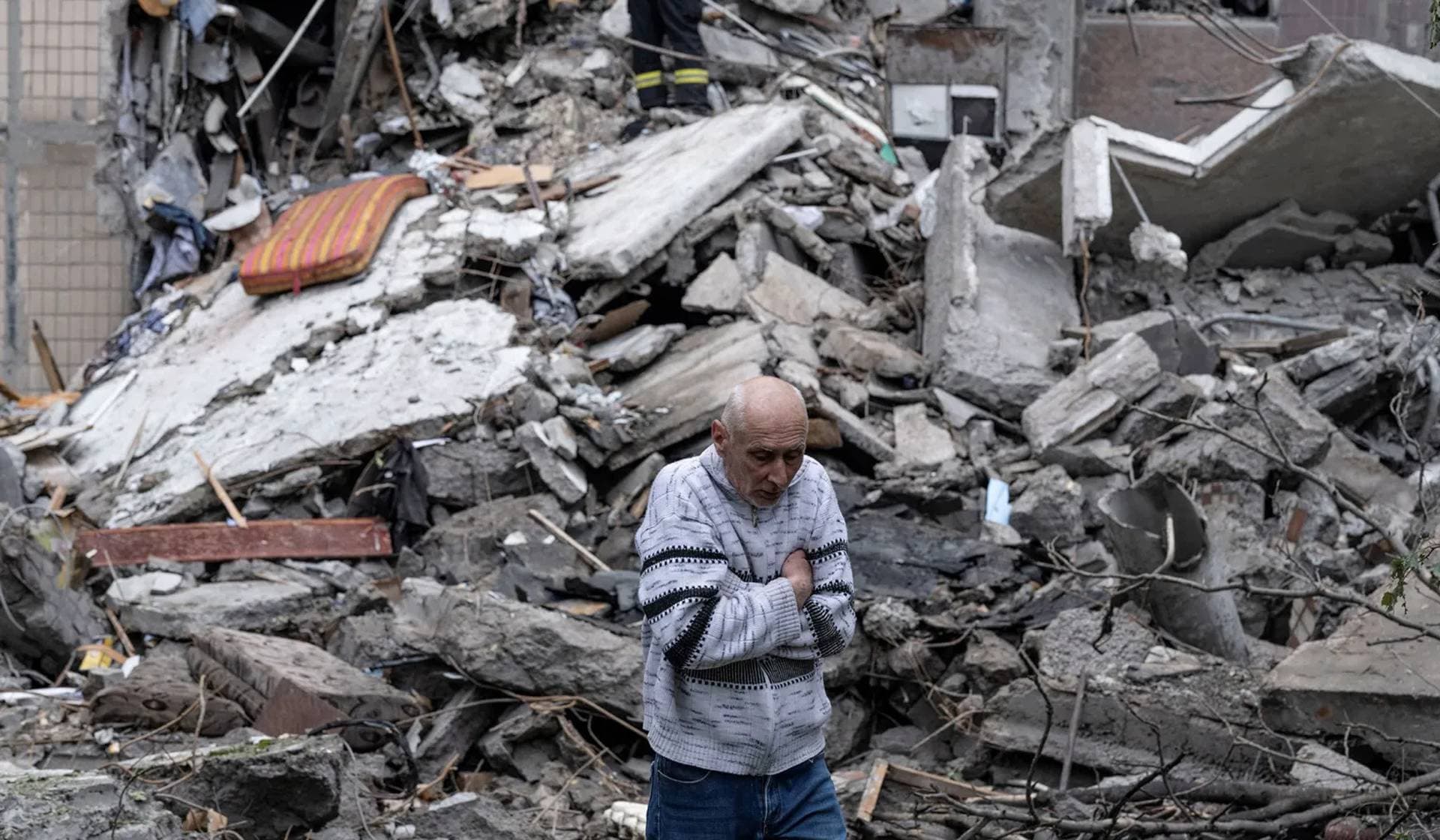 A resident reacts in front of his apartment building while rescuers try to find his mother under debris in the frontline town of Kostiantynivka