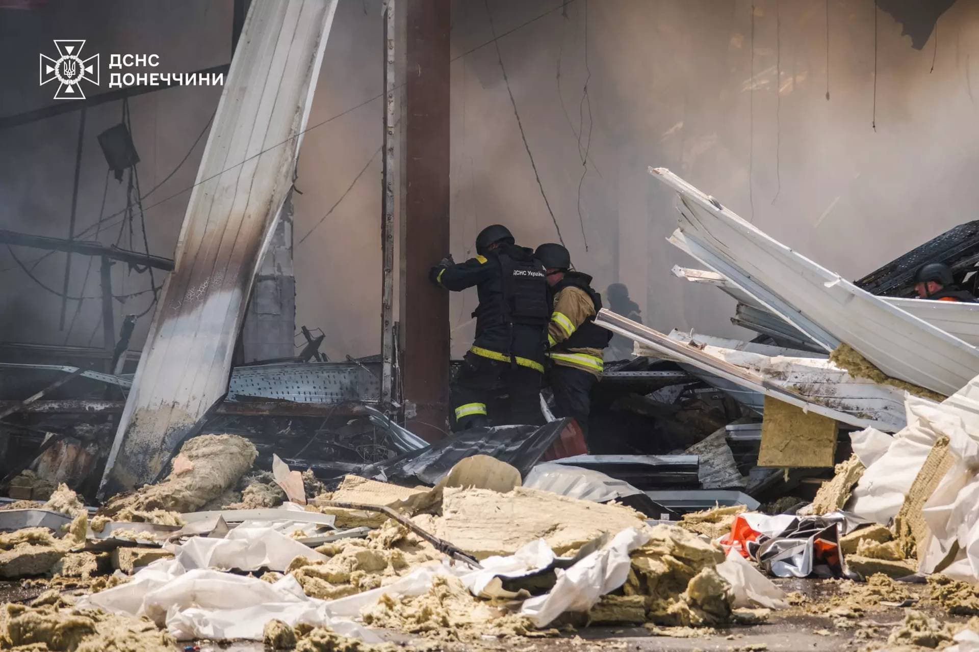 Firefighters work inside a supermarket heavily damaged by a Russian military strike in Kostiantynivka