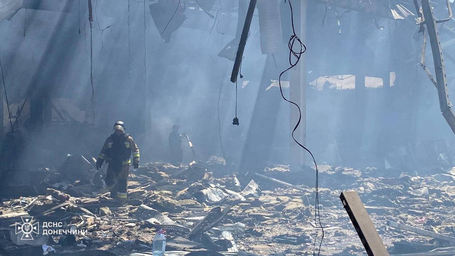 Firefighters work inside a supermarket heavily damaged by a Russian military strike in Kostiantynivka