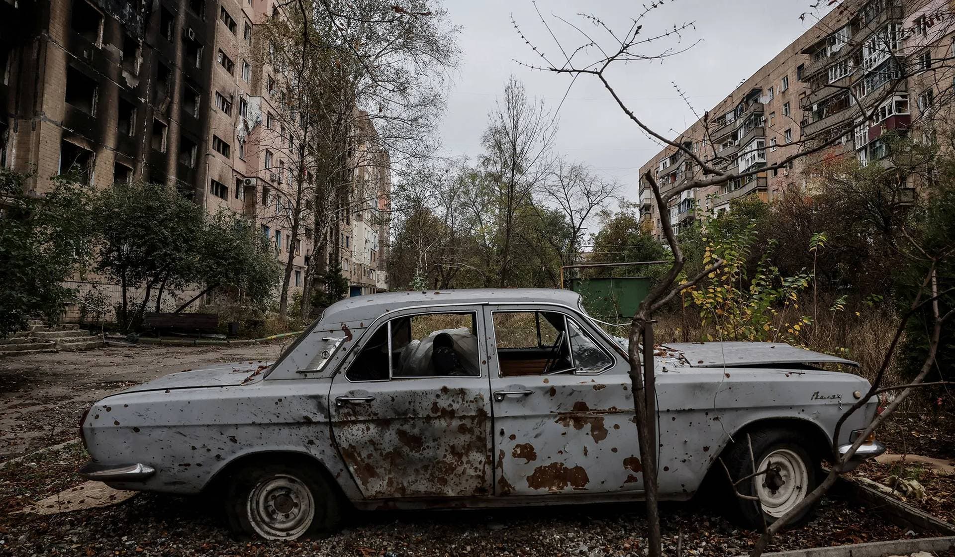A destroyed car stands near apartment buildings damaged by Russian military strike in the frontline town of Kostiantynivka