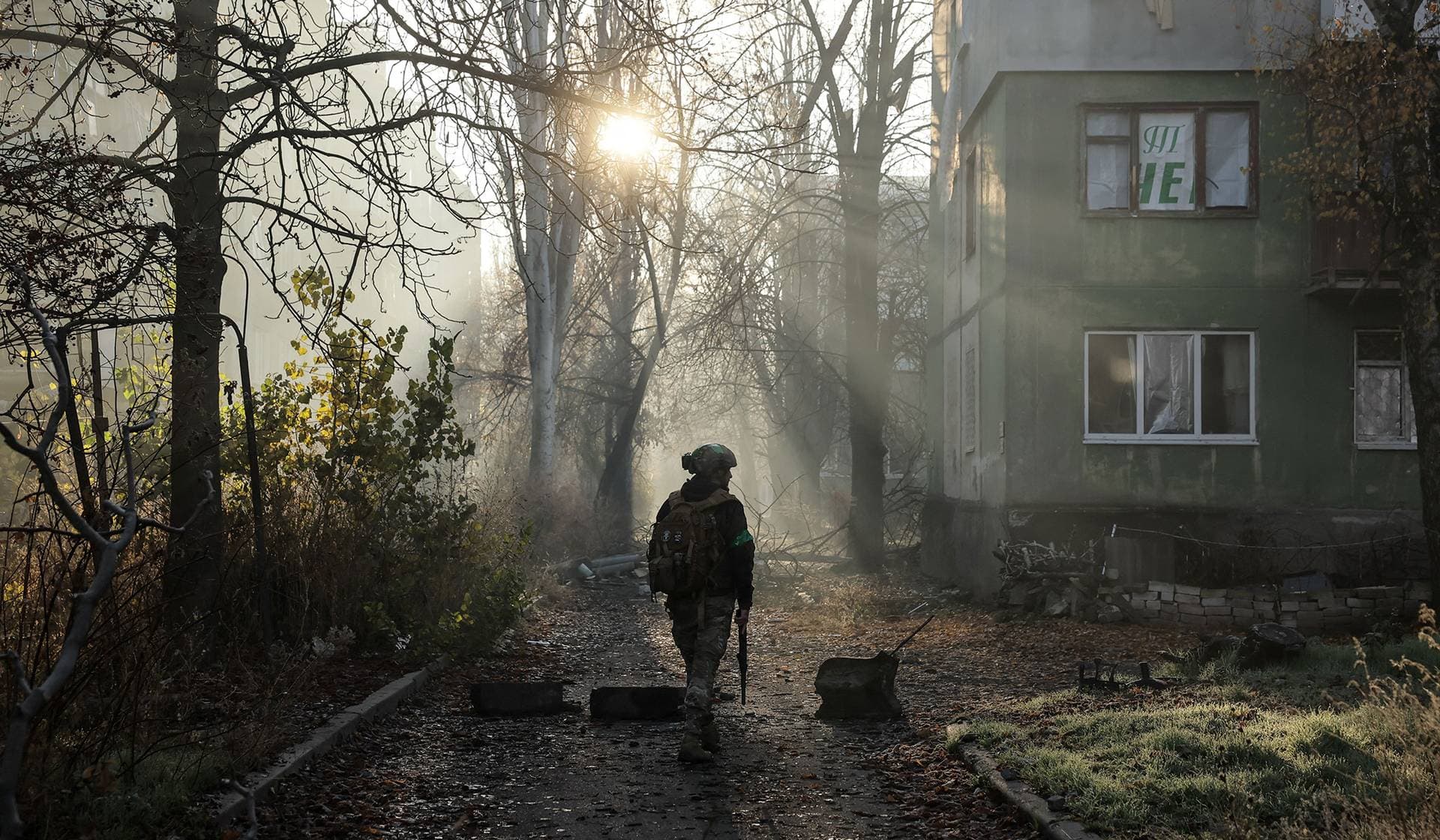 A Ukrainian serviceman walks near apartment buildings damaged by Russian military strike in the frontline town of Kostiantynivka