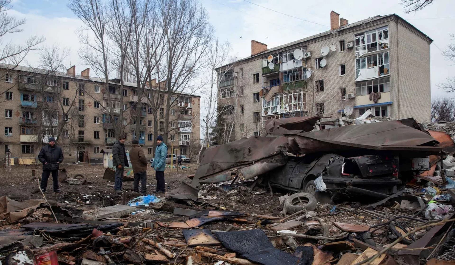 Local residents stand at a site of a Russian missile strike in Kostiantynivka