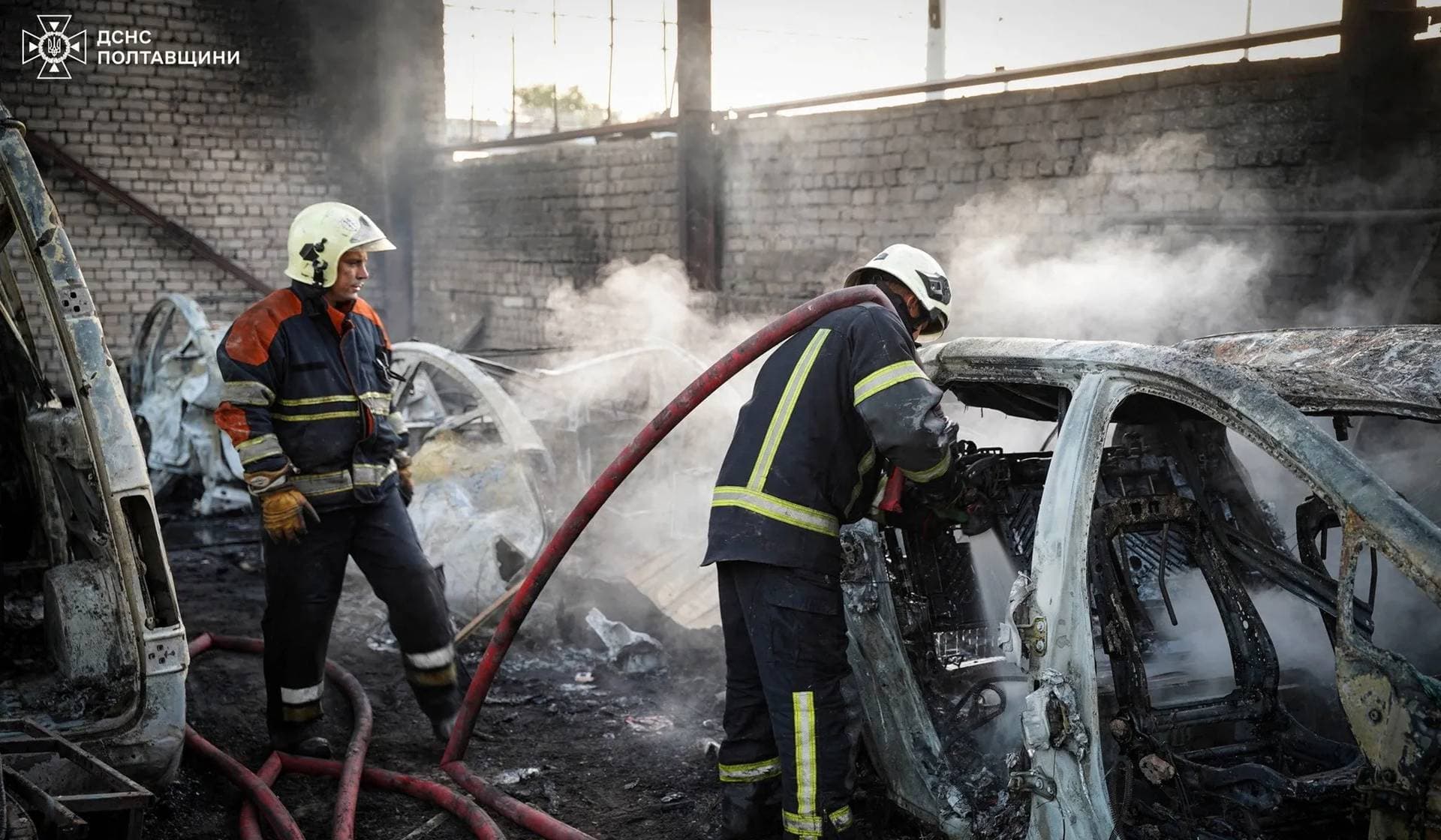 Firefighters work at the site of a transport enterprise hit during Russian drone and missile strikes in Kremenchuk