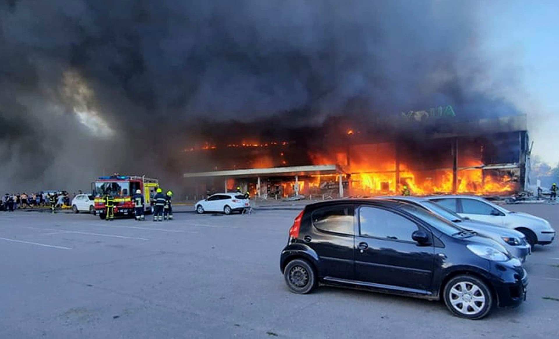 firefighters work to extinguish a fire at a shopping center burned after a rocket attack in Kremenchuk