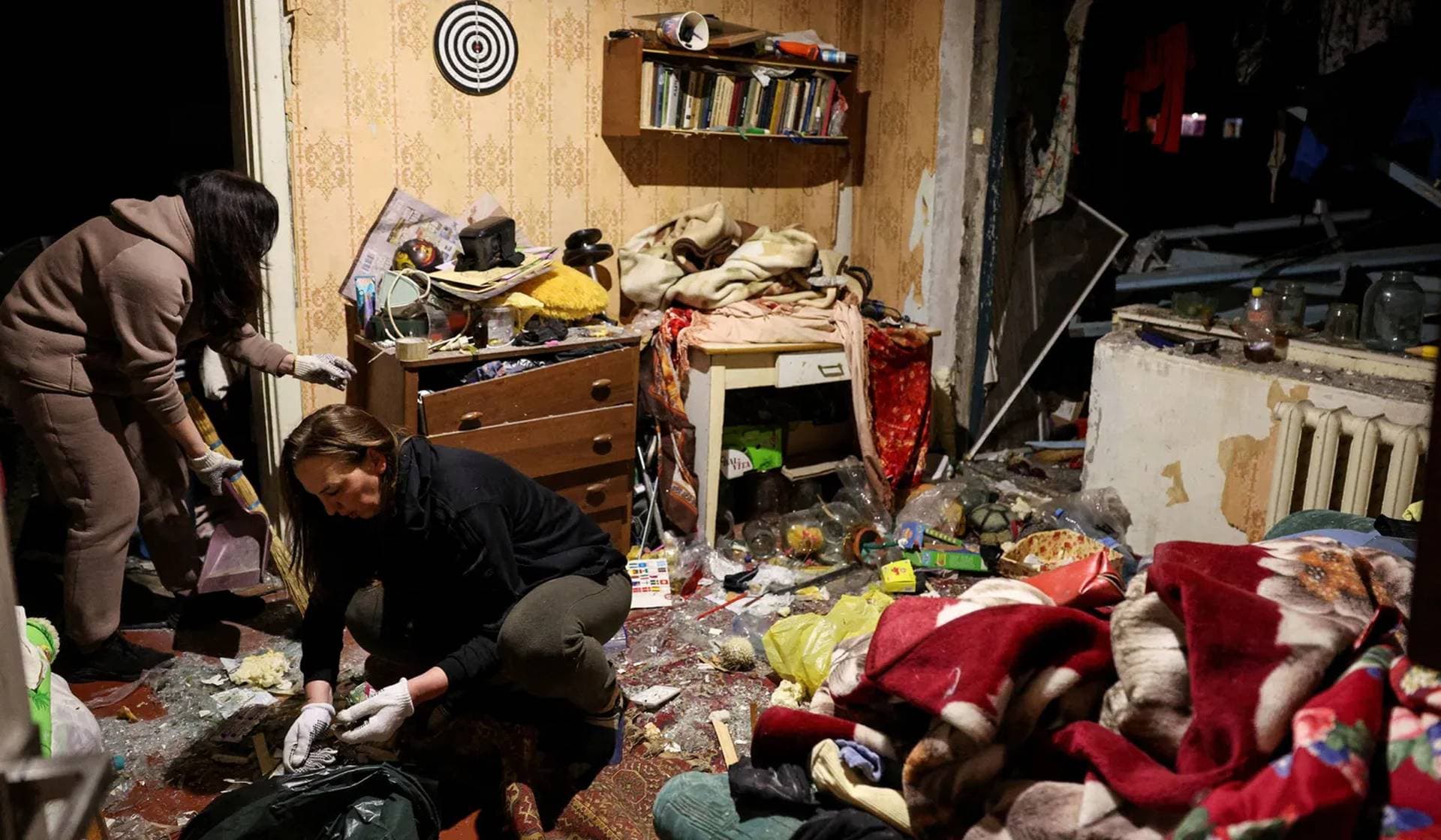 People clean inside a house that was damaged by a Russian missile strike in a residential area, in Kryvyi Rih