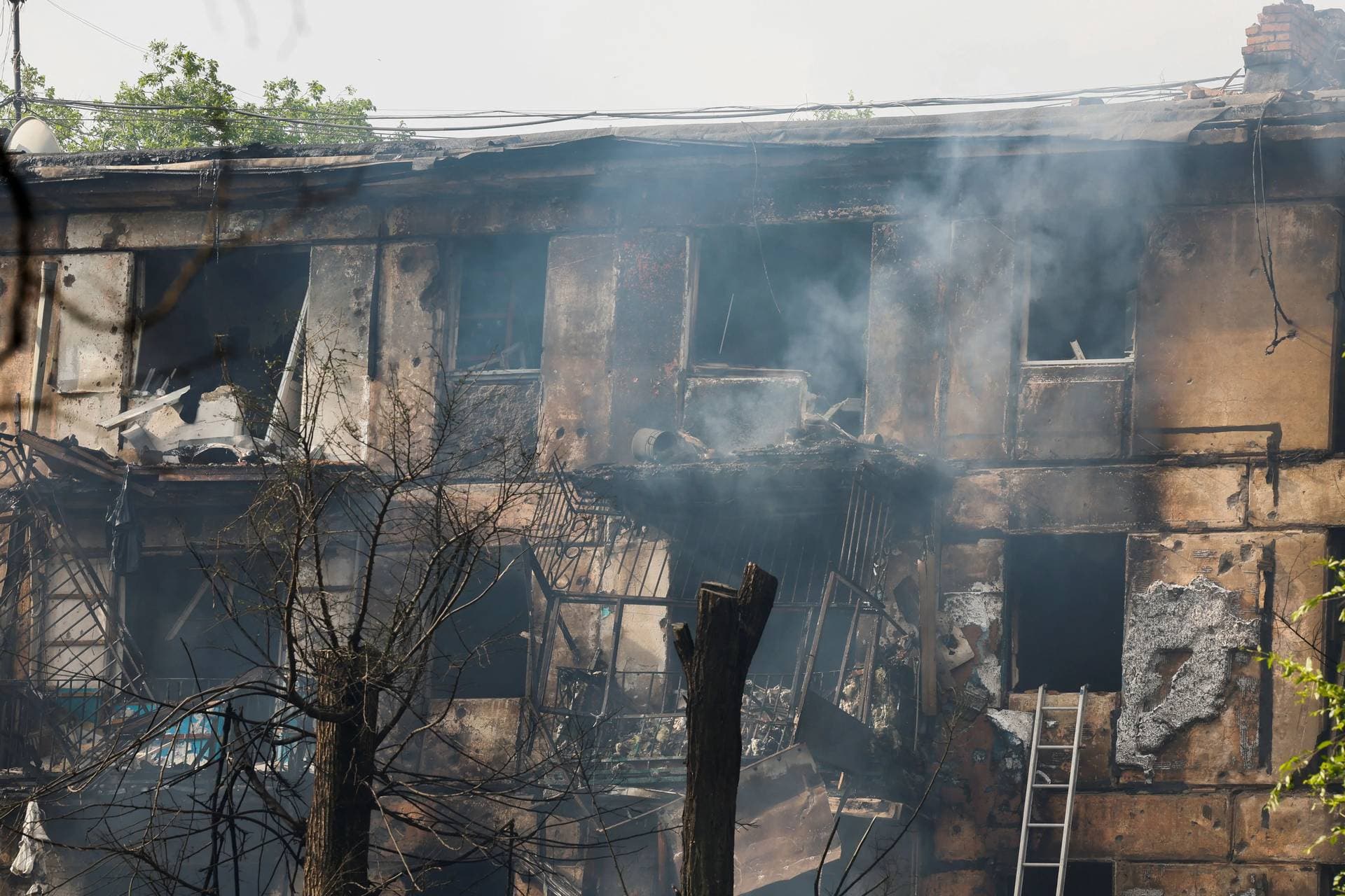 Smoke billows from the burned-out apartment building