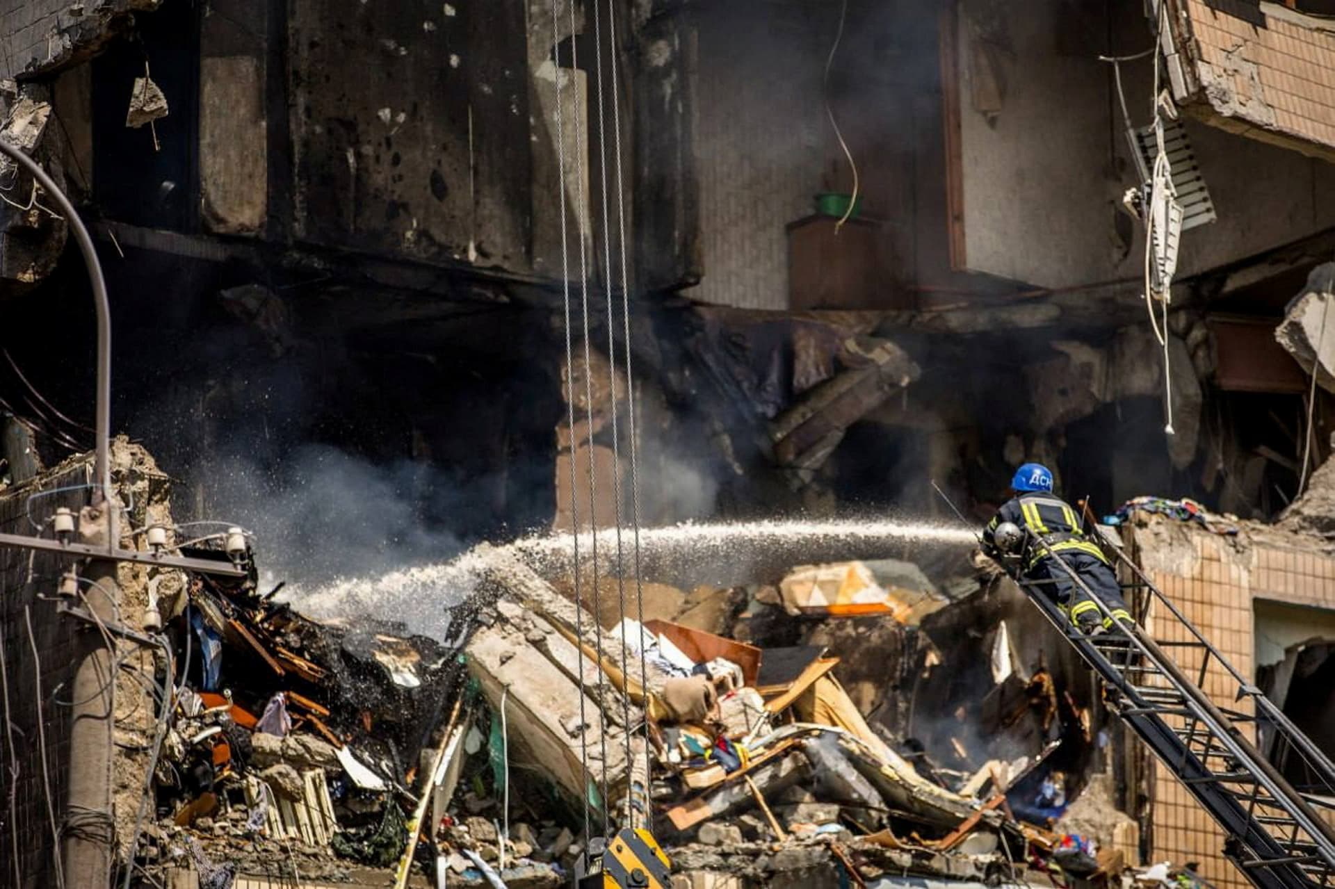 A firefighter works at the site of an apartment building heavily damaged by a missile strike in Kryvyi Rih
