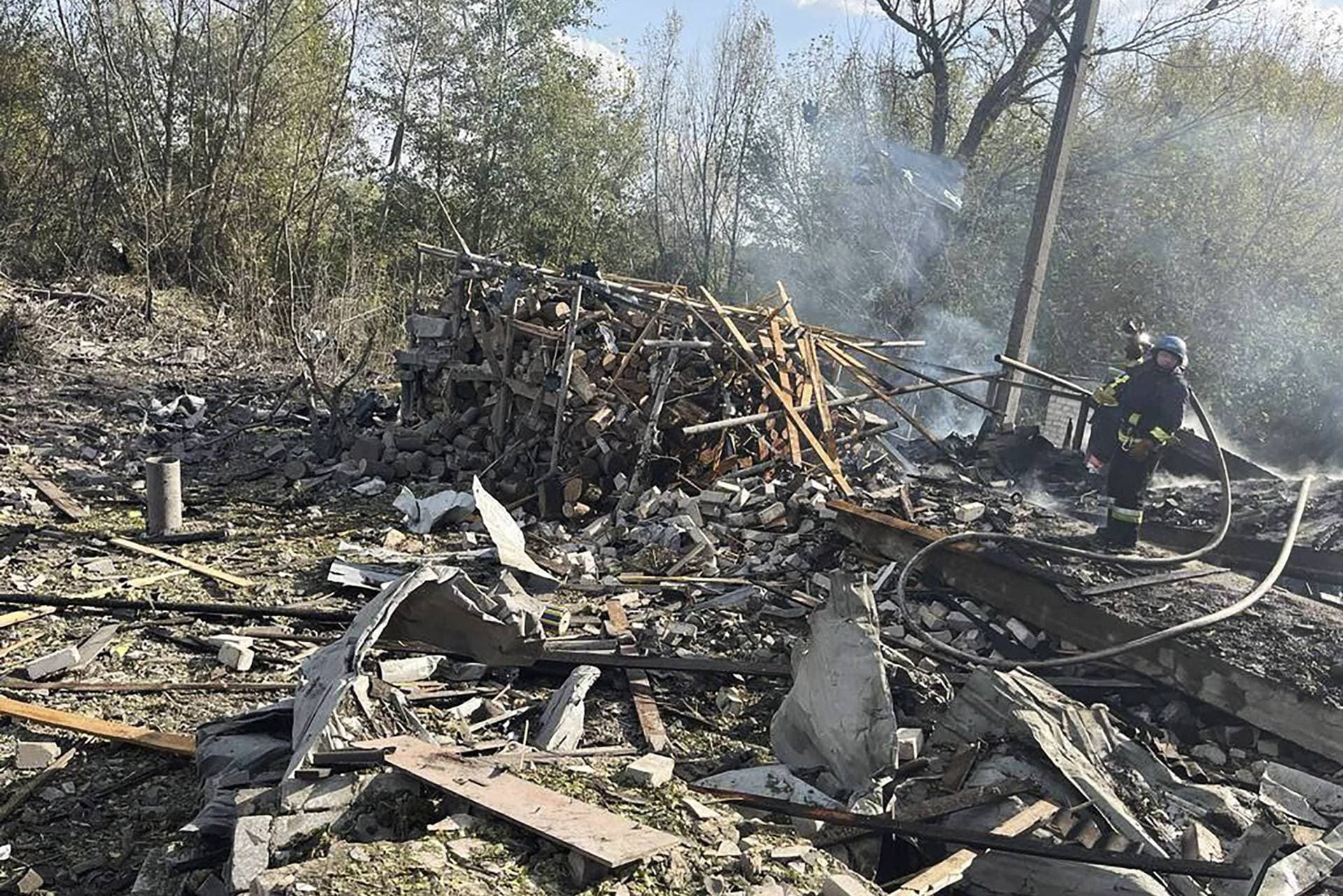 emergency workers search the victims of a Russian rocket attack that killed at least 47 people in the village of Hroza