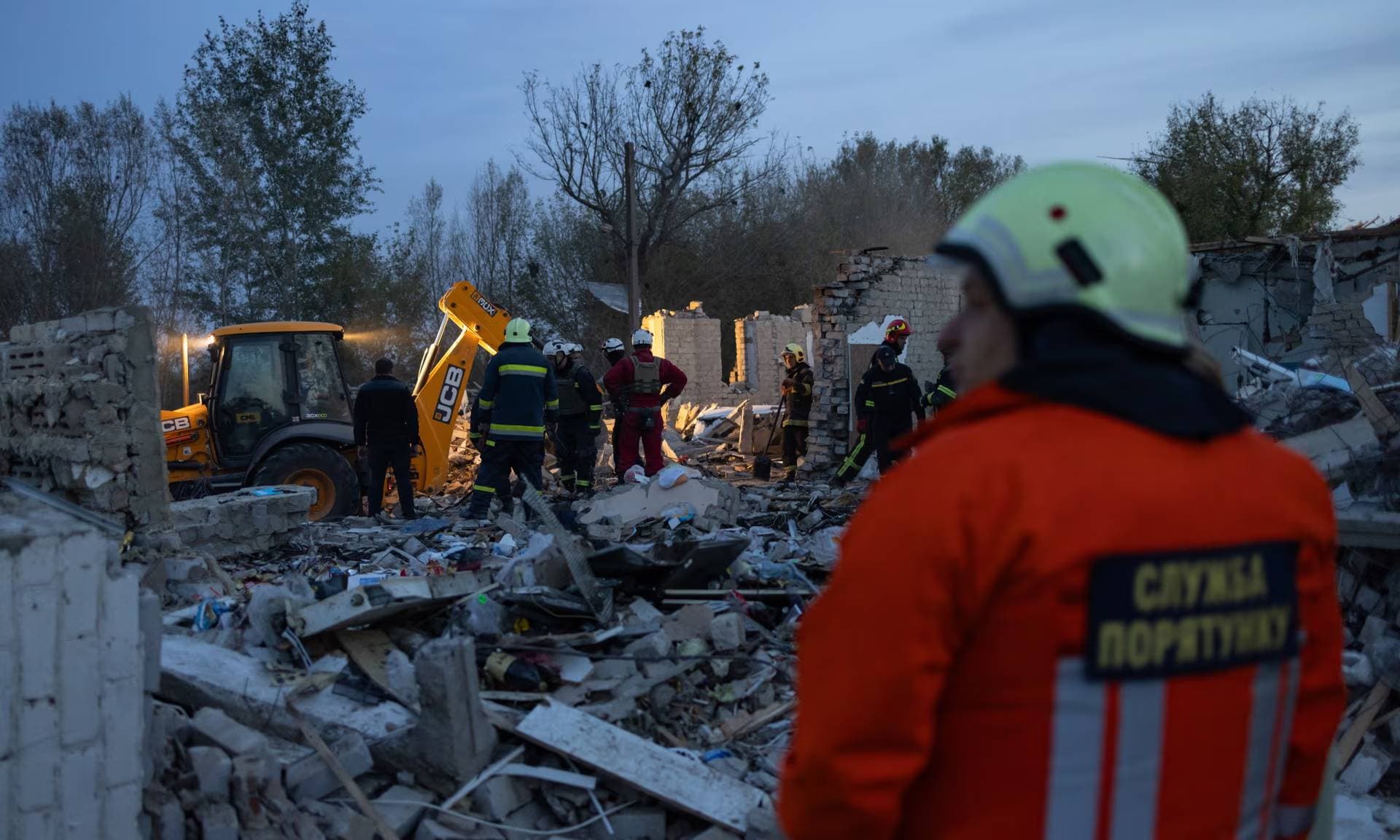 A view of the area as police and military experts working at a site of a missile strike in the village of Hroza