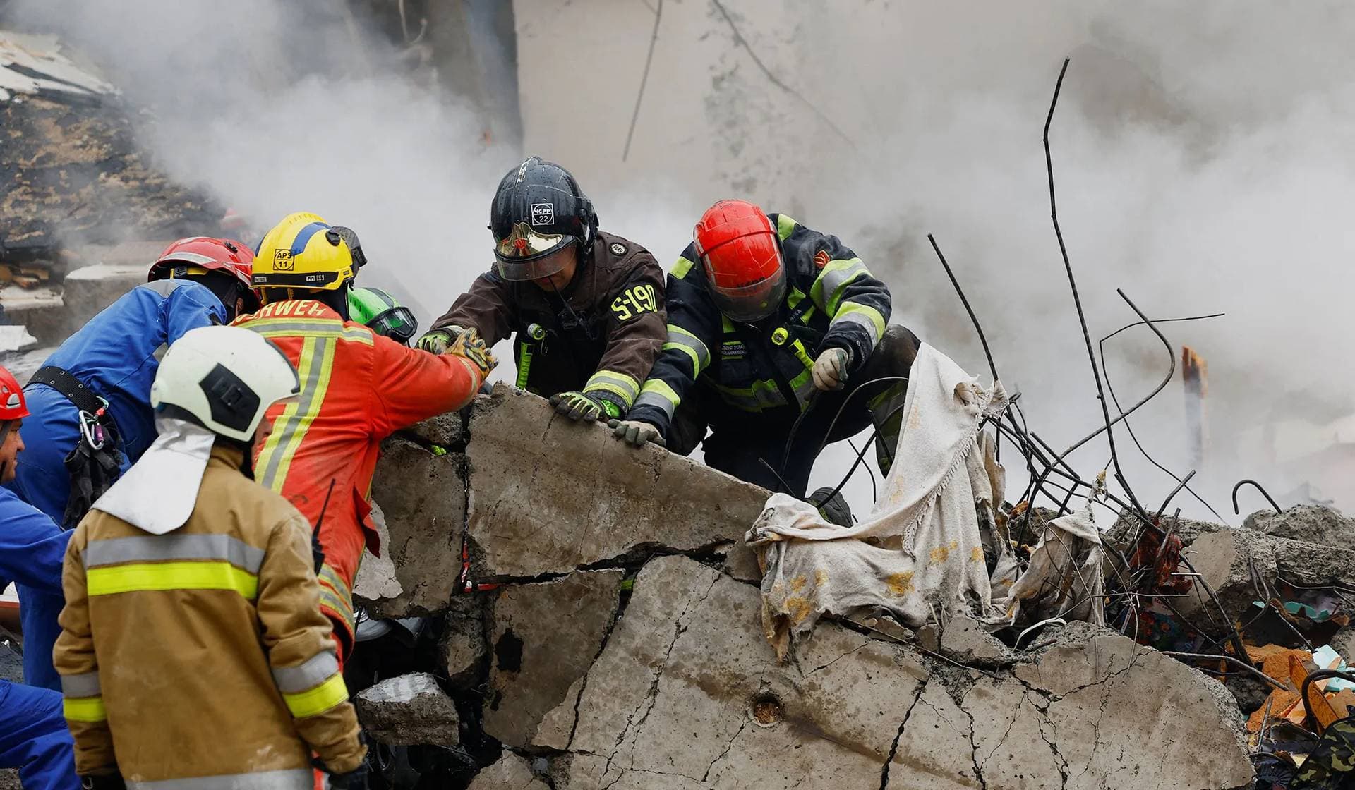 Rescuers work at the site of an apartment building hit during Russian missile and drone strikes in Kyiv