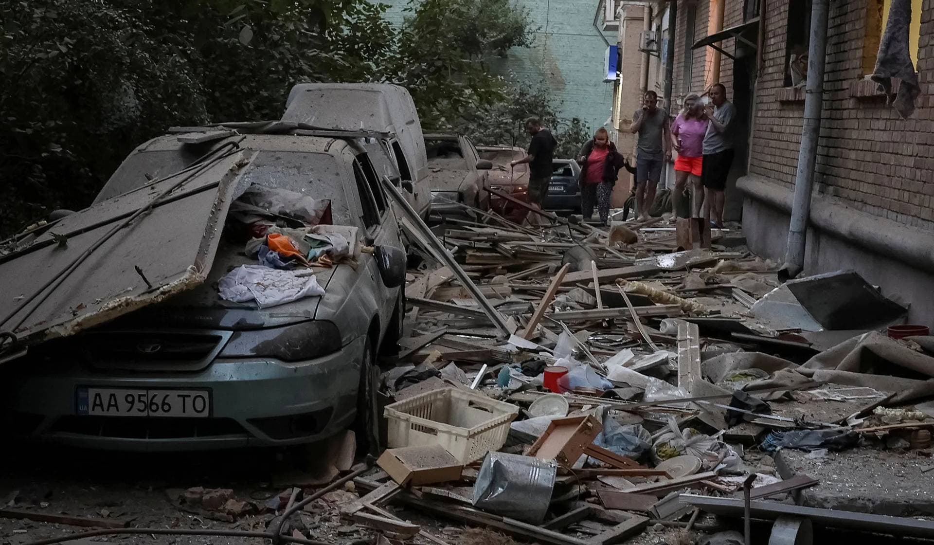 Residents stand near their apartment building that was hit during Russian drone and missile strikes in Kyiv