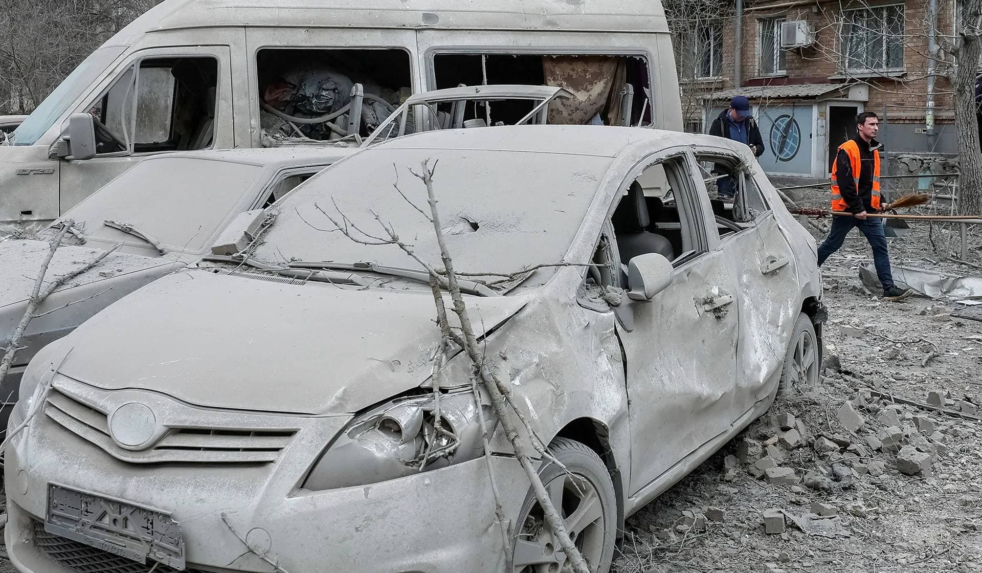 A communal worker walks at the site of a building damaged by a Russian missile strike in Kyiv