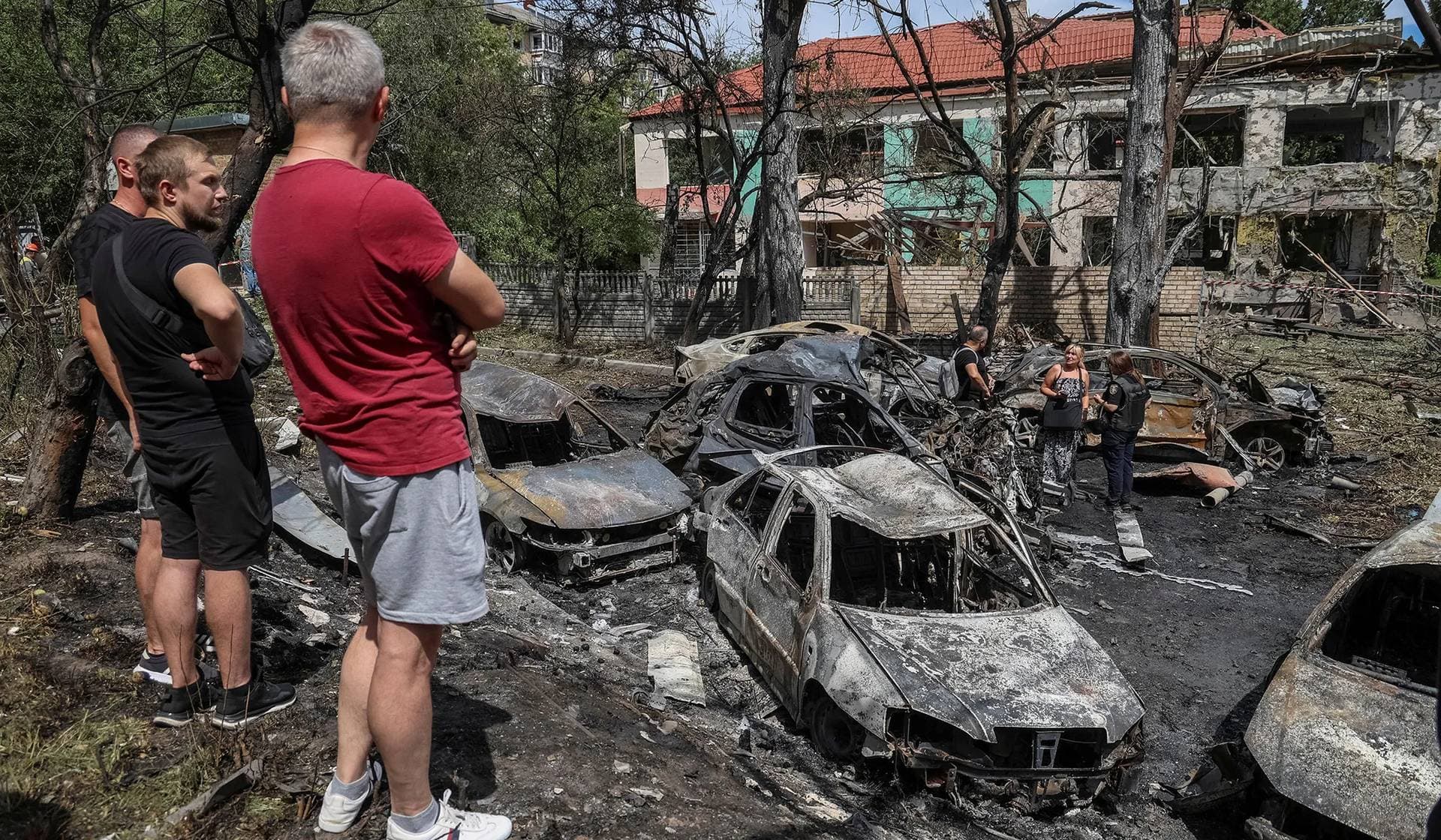 Local residents stand at the site of a Russian missile strike in Kyiv