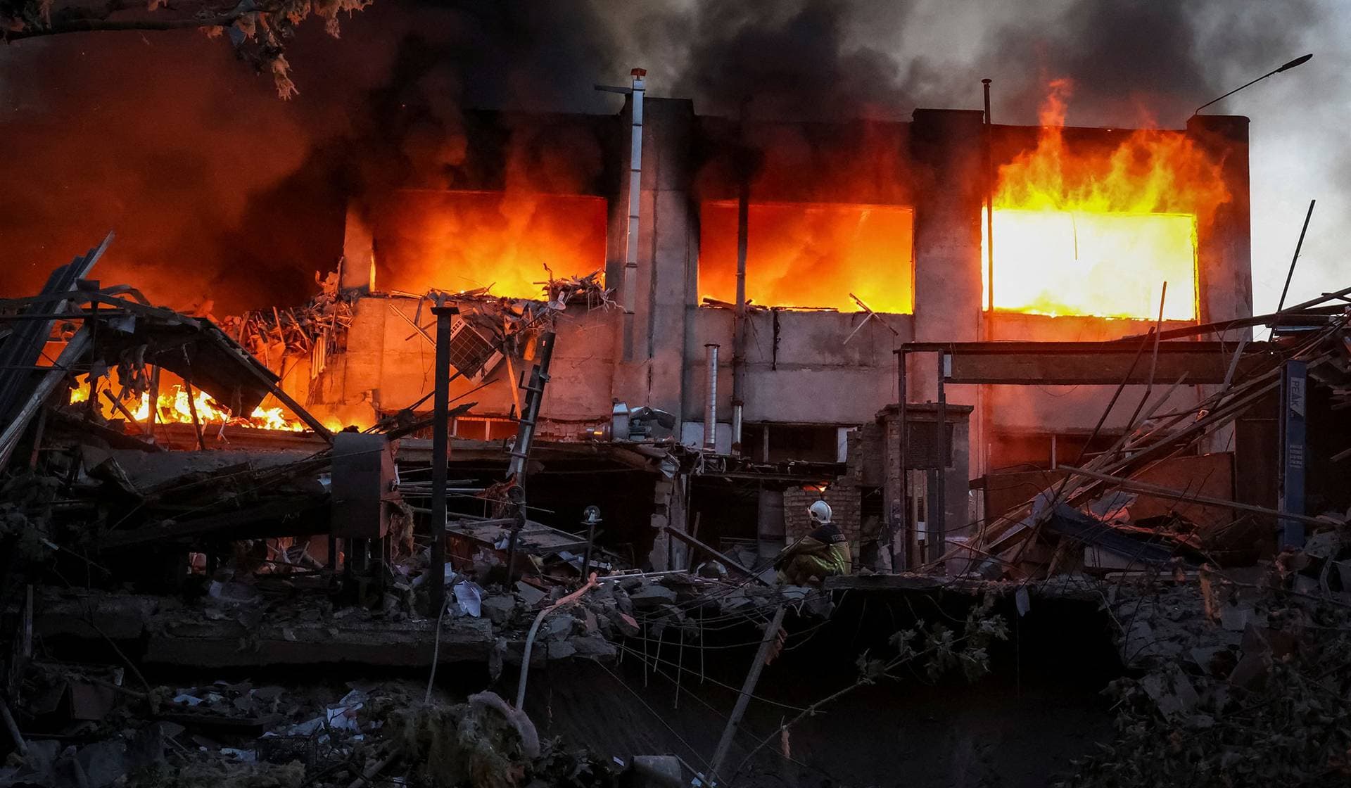 A rescuer sits at a site of a Russian drone and missile strike in Kyiv