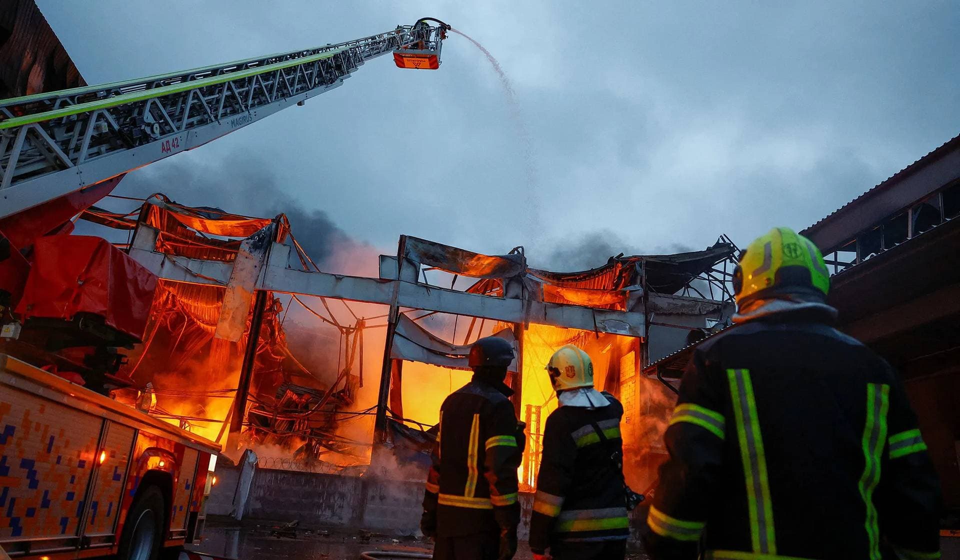 Firefighters work at the site of food warehouses hit by an overnight Russian missile strike in Kyiv